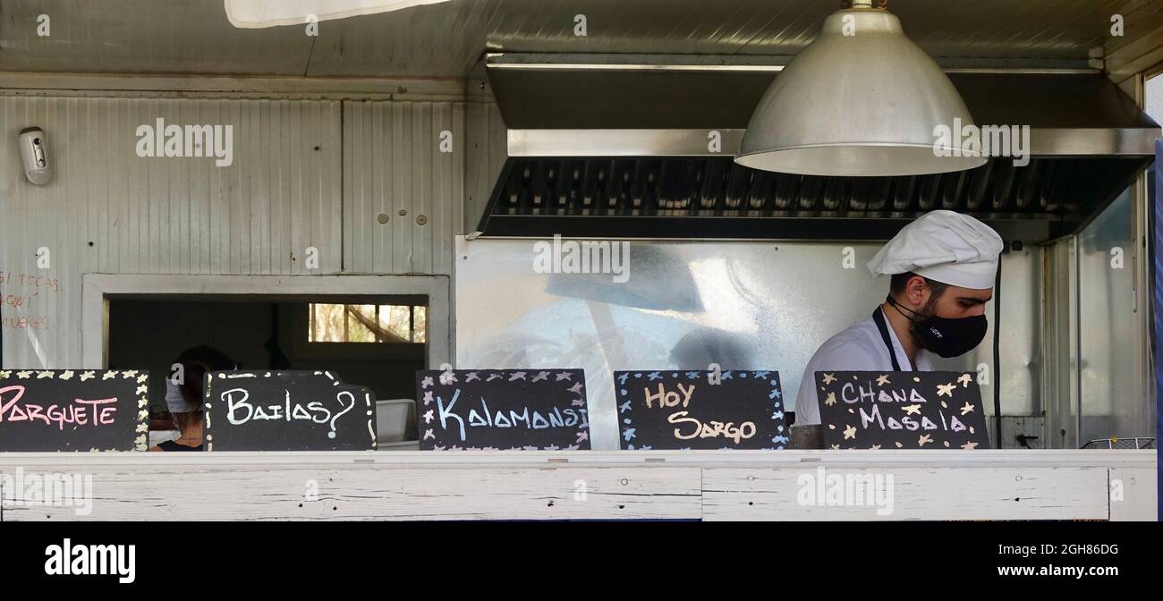 El Rompido (Huelva), Spagna; 30 agosto 2021: Uomo con una maschera di cottura del pesce in un bar sulla spiaggia a Huelva (Spagna) Foto Stock