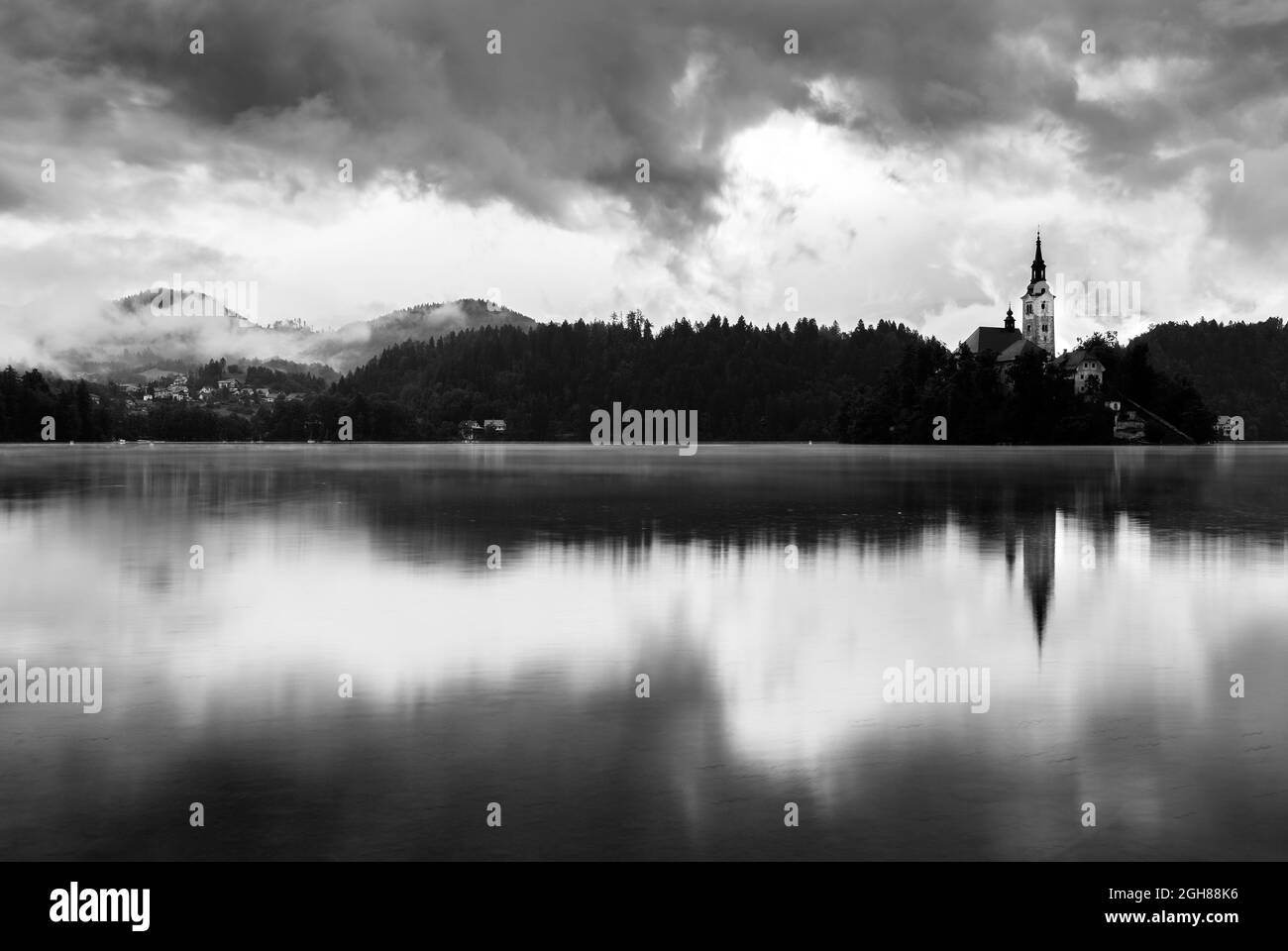 Mattina presso l'isola del lago di Bled chiesa dell'assunzione di santa maria dopo una notte di forte pioggia estiva, Slovenia. Foto Stock