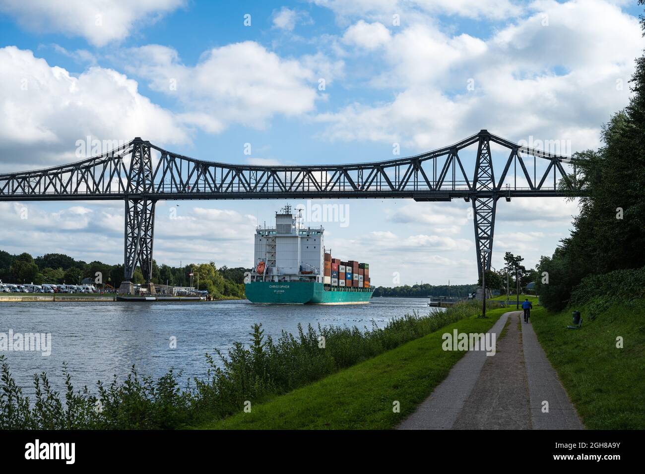 Das Containerschiff Christoper im Nord-Ostsee-Kanal Richtung Kiel passiert die Eisenbahnhochbrücke a Rendsburg Foto Stock