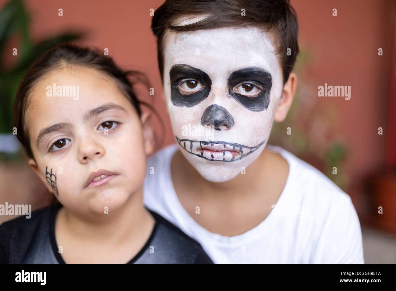 Primo piano ritratto di ragazzo caucasico e bambina con make-up per giorno dei morti. (Dia de los Muertos). Foto Stock