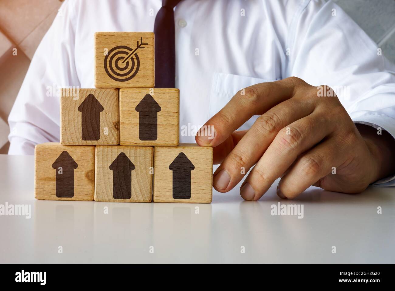 Concetto di successo aziendale. Cubi con frecce e bersaglio sulla parte superiore. Raggiungere gli obiettivi. Foto Stock