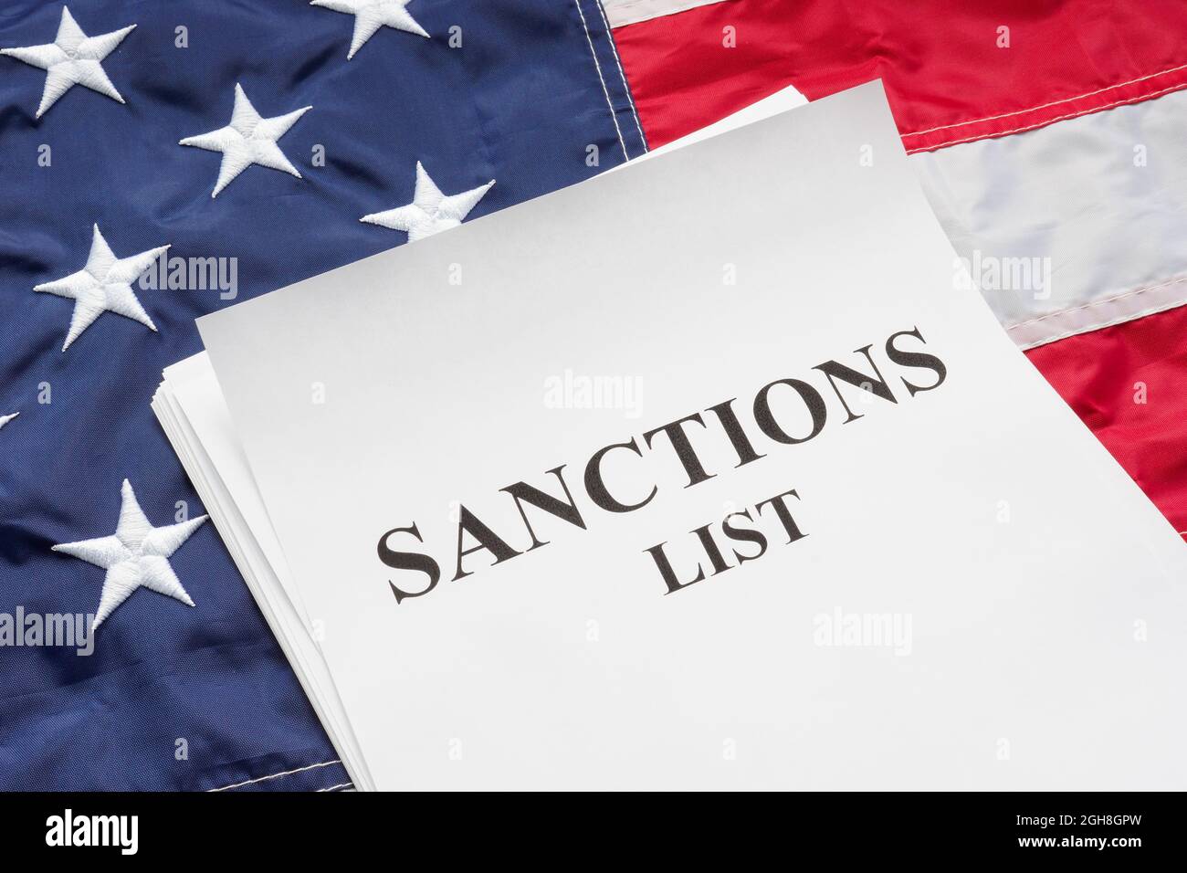 La bandiera degli Stati Uniti e le sanzioni elencano un mucchio di documenti su di essa. Foto Stock