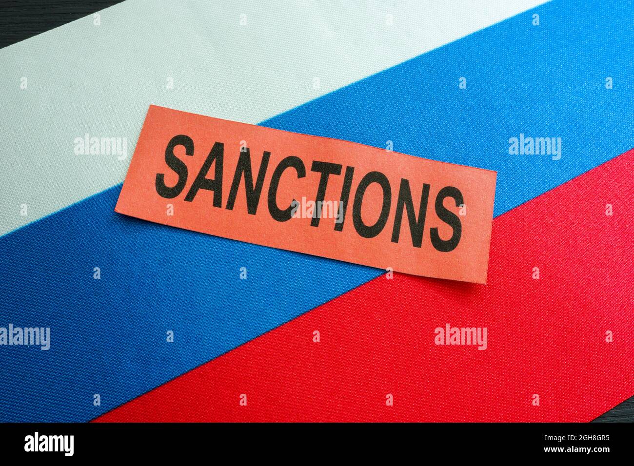La bandiera russa e la parola sanzioni come simbolo di restrizioni economiche. Foto Stock