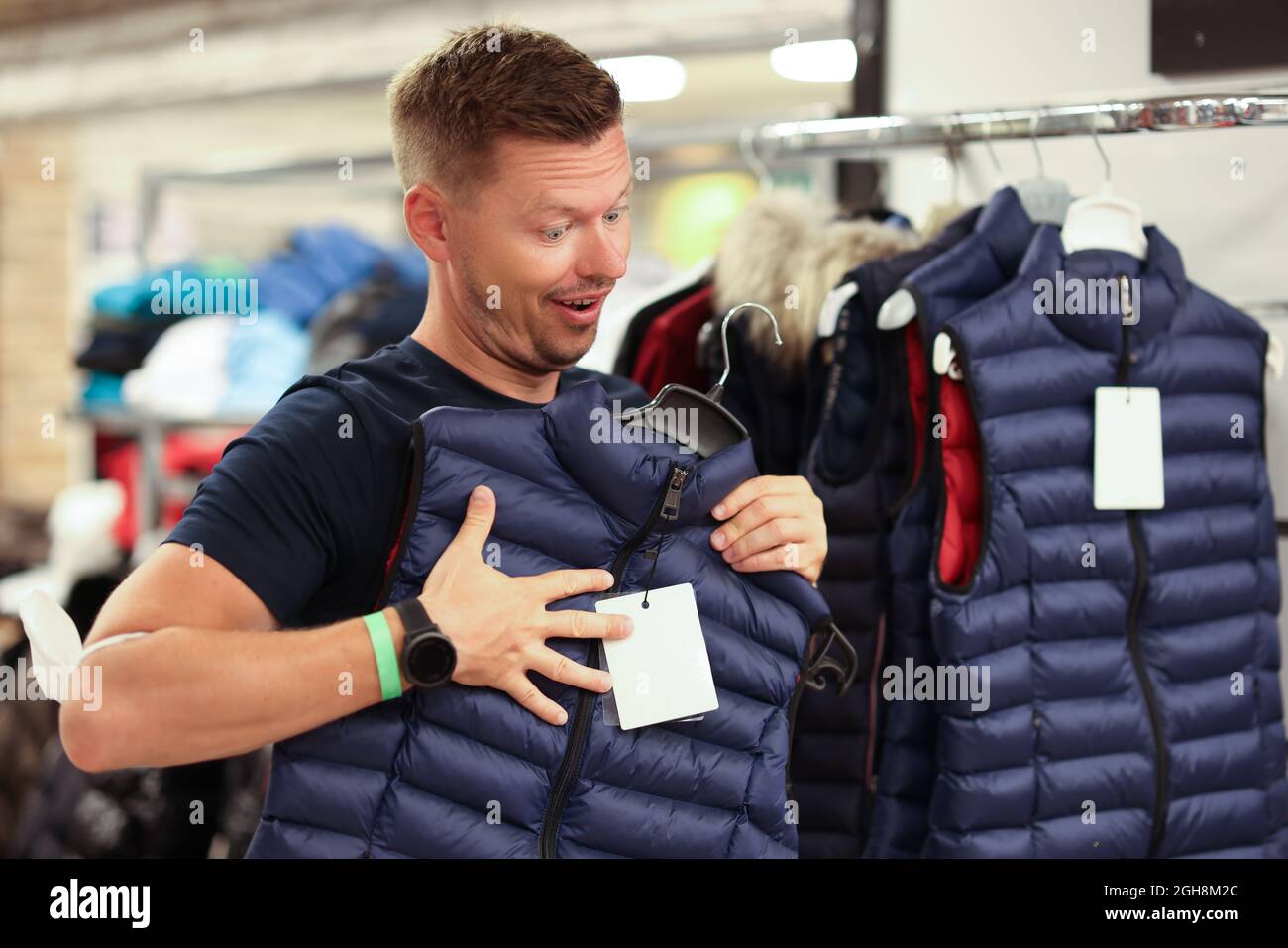 L'uomo prova sul gilet caldo nel primo piano del deposito Foto Stock