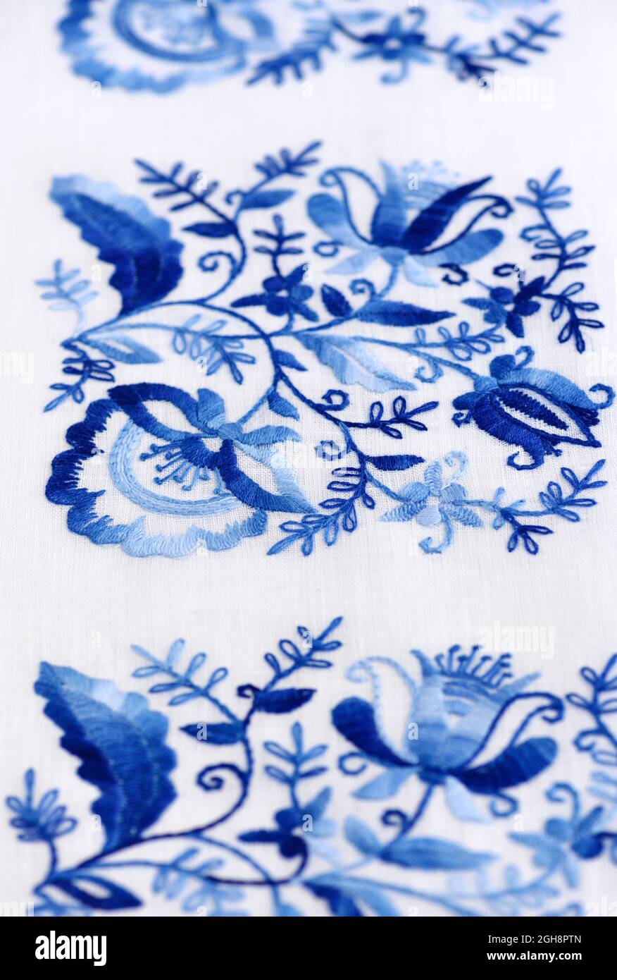 Ricamo a mano cucito su una tela sottile. Ornamento floreale blu su sfondo  bianco. Arte e concezione artigianale Foto stock - Alamy