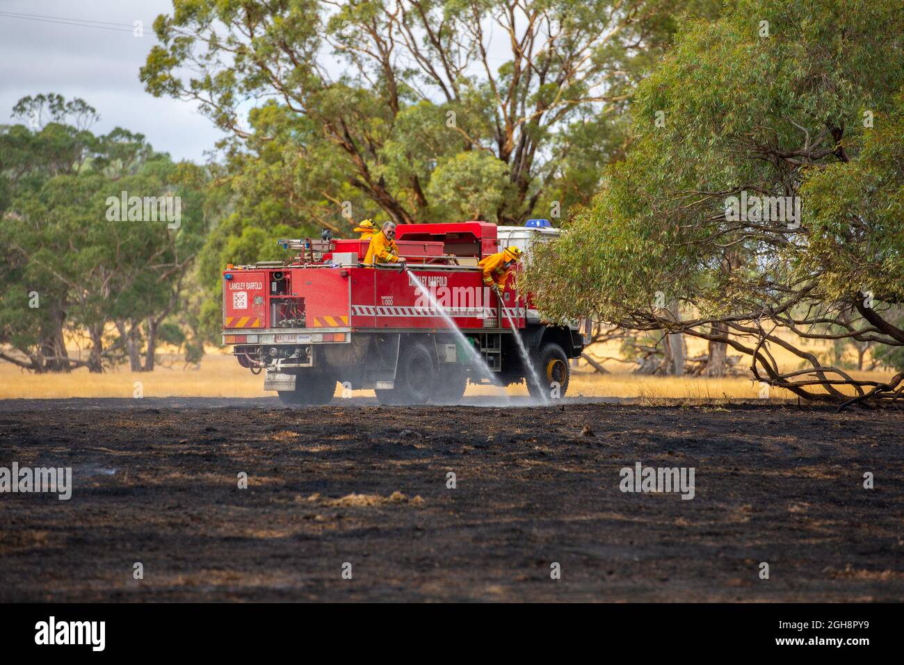 Un apparecchio antincendio che mette fuori un fuoco di erba, Langley Barfold, Victoria, Australia. Foto Stock