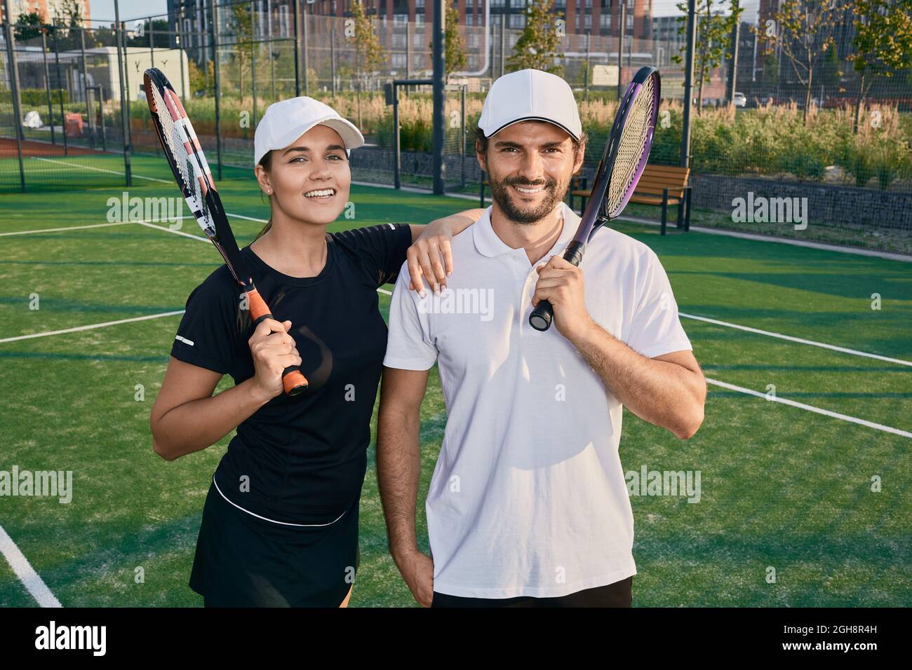 Bella coppia di giocatori di tennis felice dopo aver giocato a tennis all'aperto Foto Stock