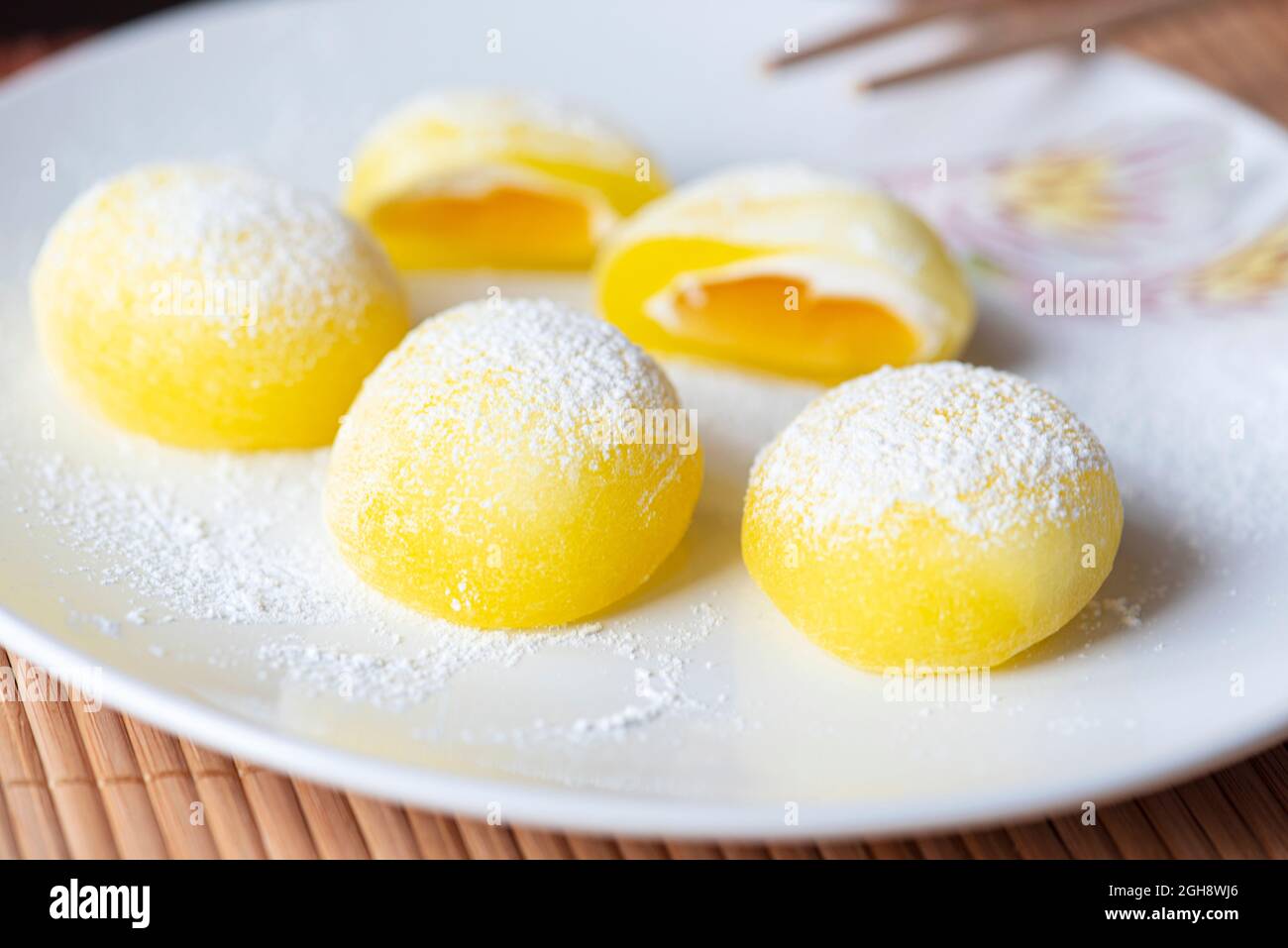 Mochi su un piatto bianco. Dessert di riso giallo, mochi è per lo più tradizionale cibo dolce giapponese Foto Stock