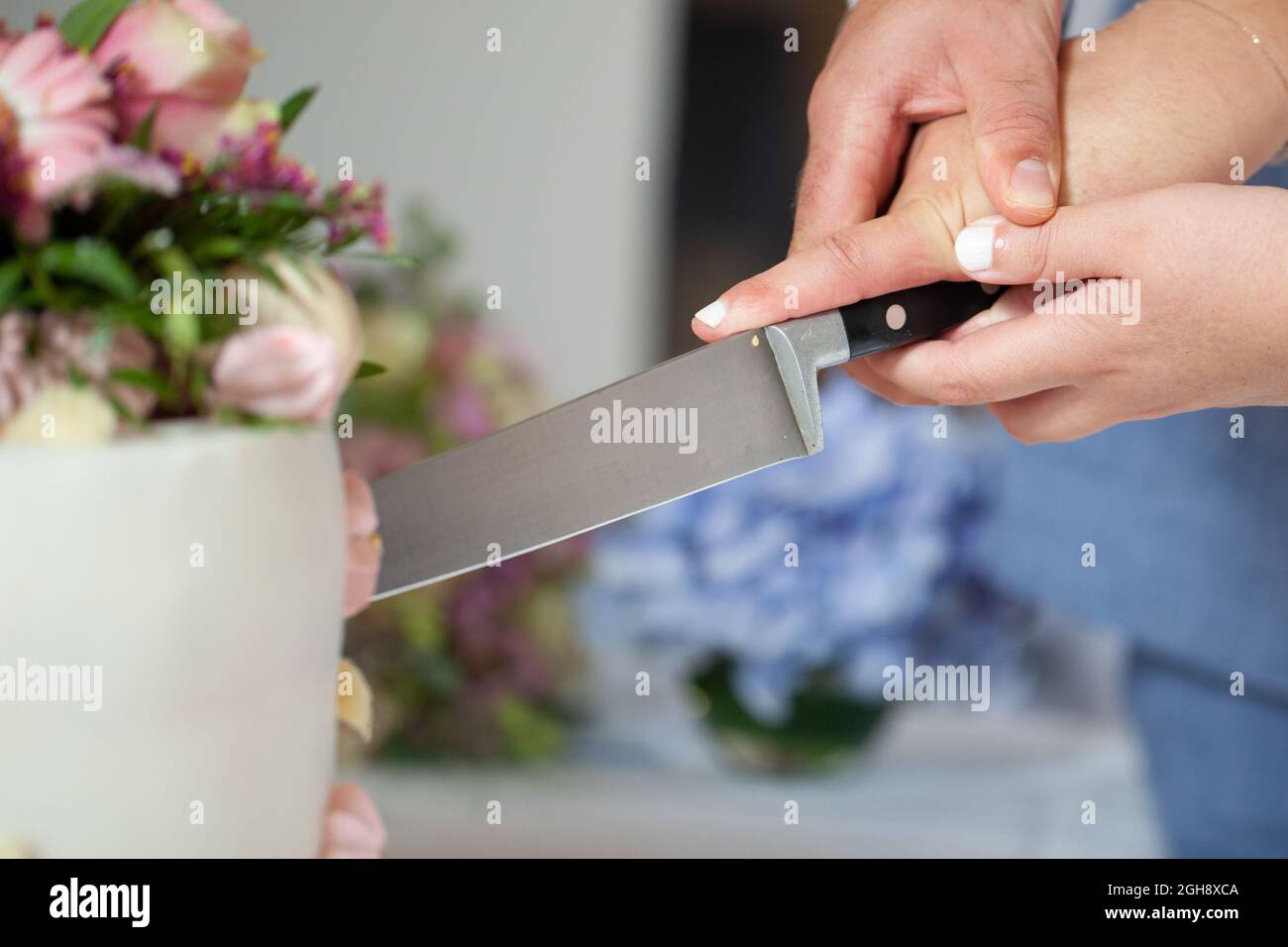 Dettaglio di sposa e sposo taglio torta di nozze dopo essere stato sposato. Foto di alta qualità Foto Stock