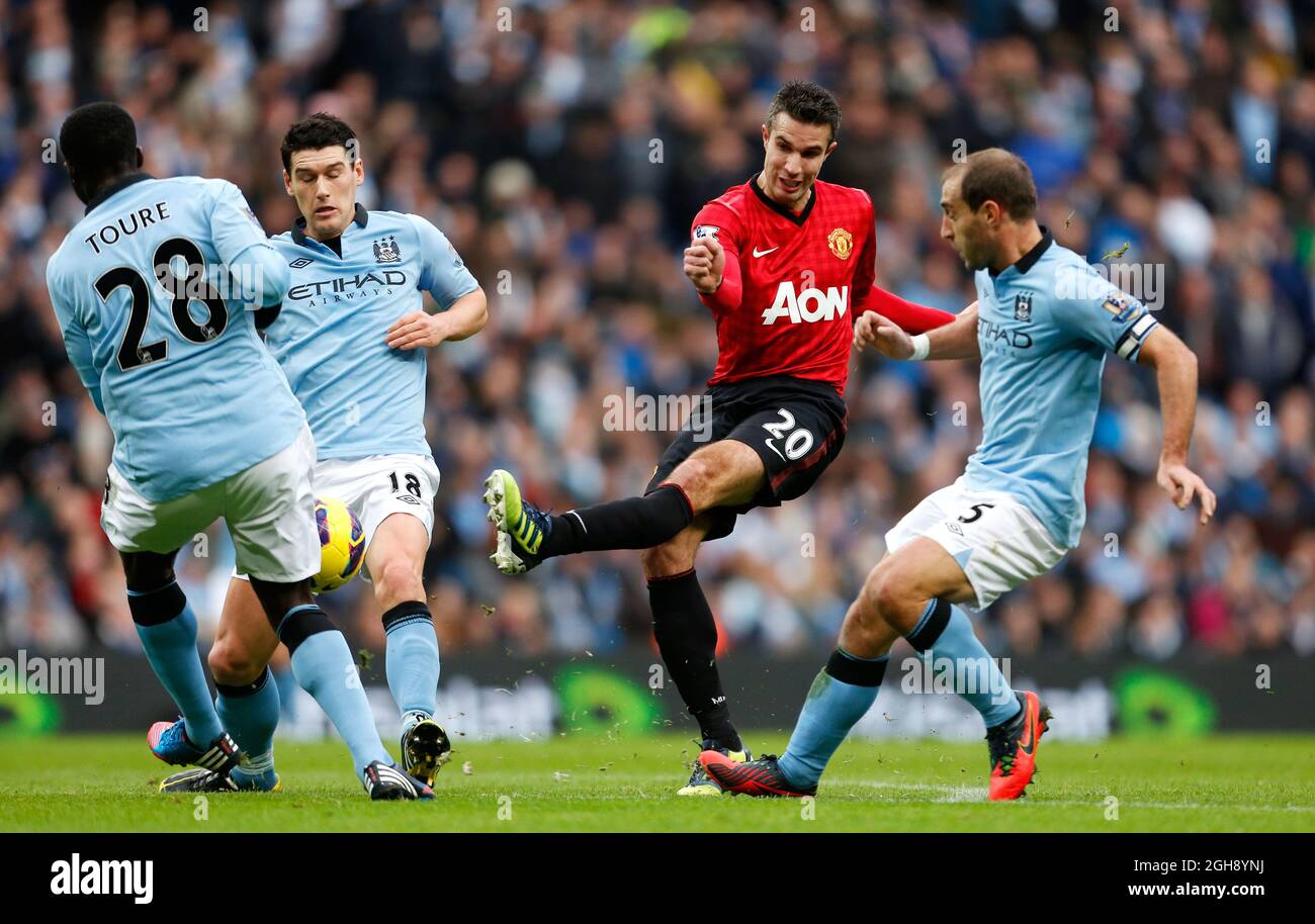 Kolo Toure (L) di Manchester City blocca un colpo al traguardo di Robin van Persie (2nd R) di Manchester United durante la partita della Barclays Premier League tra Manchester City e Manchester United all'Etihad Stadium di Manchester, Inghilterra, il 9 dicembre 2012. Foto Stock