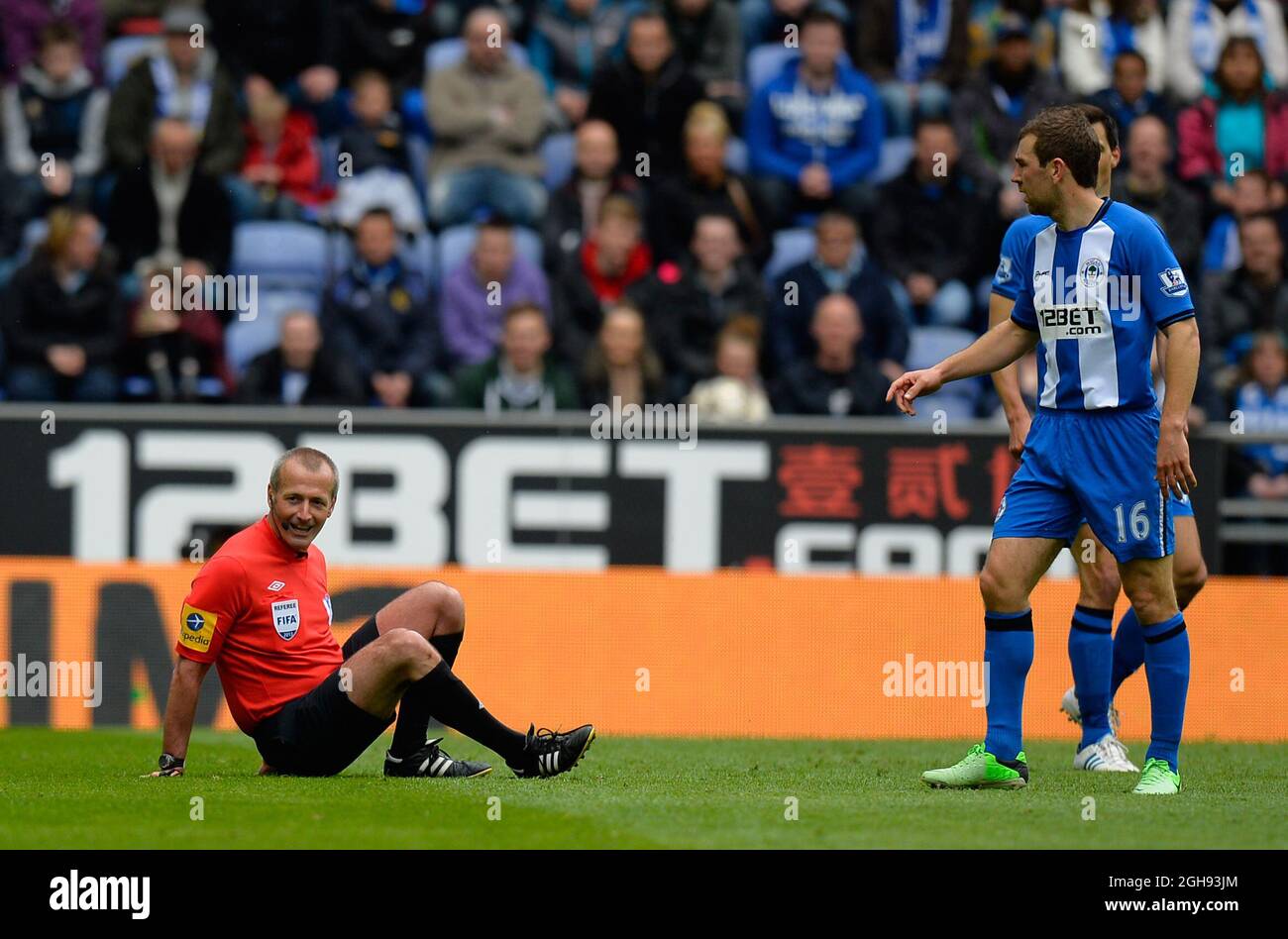 L'arbitro Martin Atkinson è scattato da James McArthur di Wigan Athletic durante la partita della Barclays Premier League tra Wigan Athletic e Tottenham Hotspur al DW Stadium di Wigan, Regno Unito il 27 aprile 2013. Foto Stock