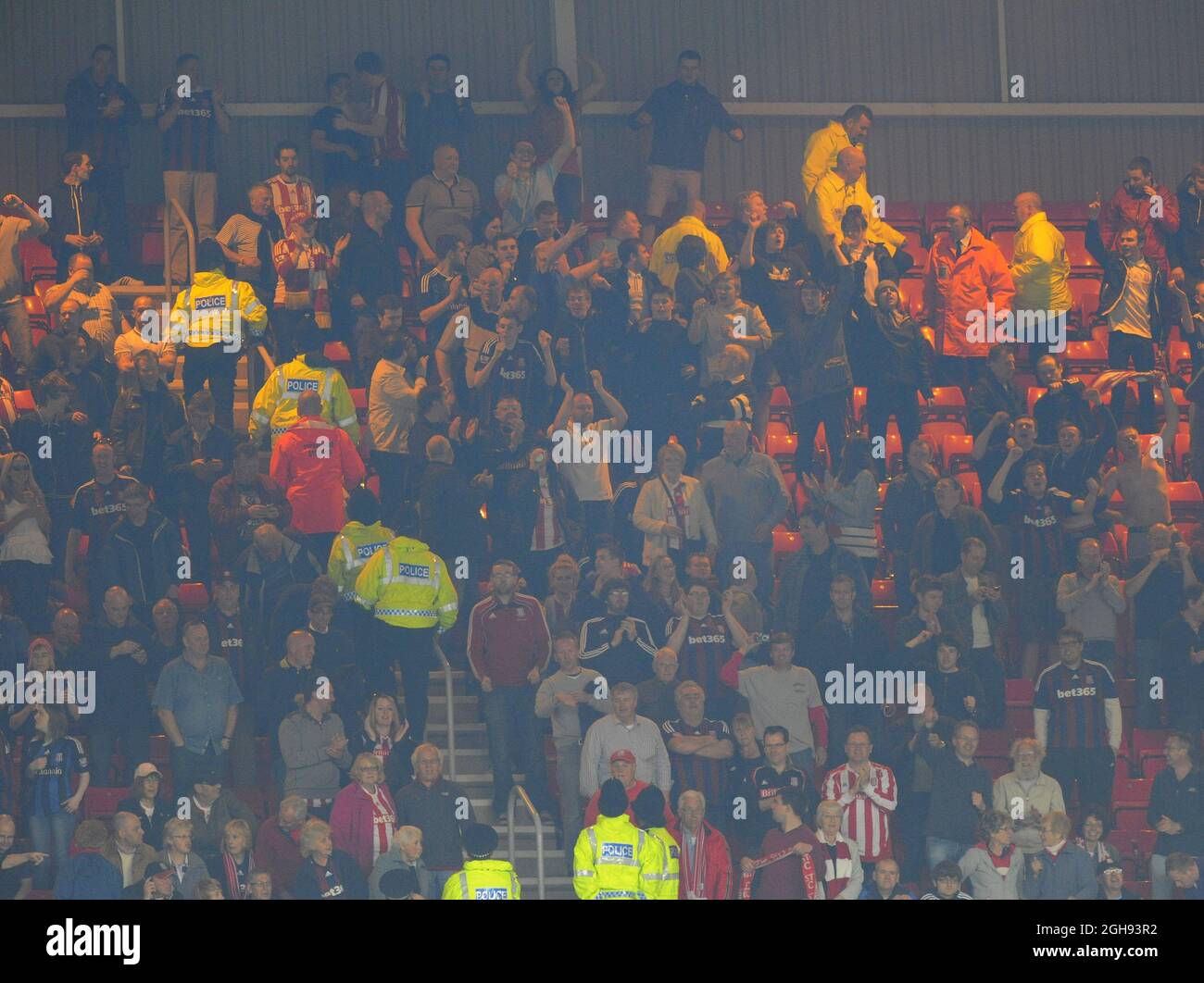 La polizia e gli steward si muovono mentre i tifosi di Stoke City hanno dato il via a un fuoco durante la partita della Barclays Premier League tra Sunderland e Stoke City allo Stadium of Light di Sunderland il 06 maggio 2013. Foto Stock