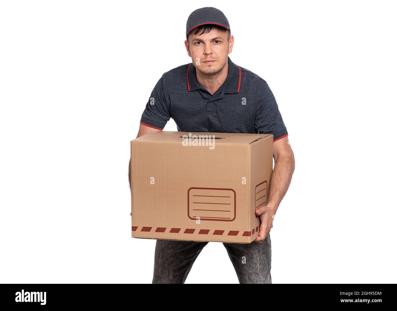 Ritratto dell'uomo di consegna in tappo che tiene contenitore pesante del pacco isolato su sfondo bianco Foto Stock