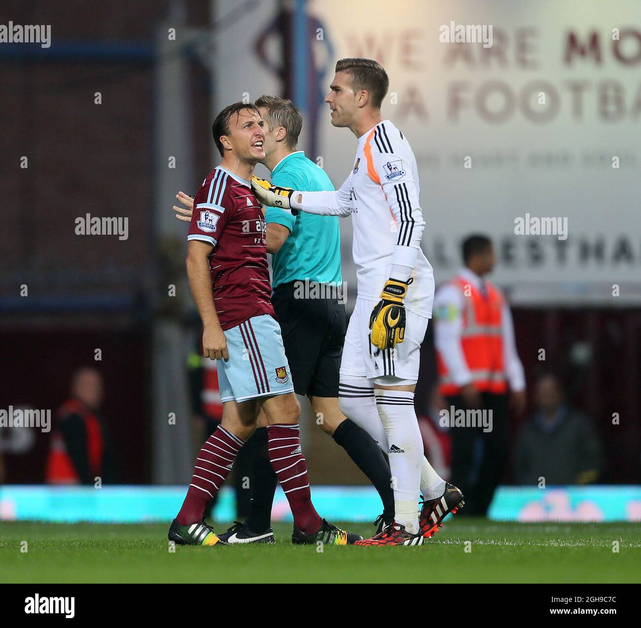 Mark Noble di West Ham esorta Adrian a calmarsi durante la partita della Barclays Premier League tra West Ham United e Liverpool tenutasi all'Upton Park di Londra, Inghilterra, il 20 settembre 2014. Foto Stock