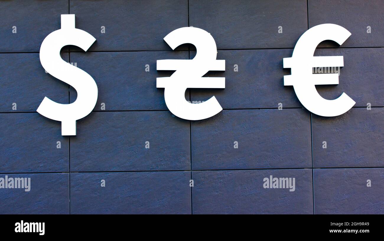Simboli del dollaro americano, euro, irivnia Ucraina su sfondo grigio. Denaro, affari, guadagni, concetto di investimento finanziario. Cambio valuta Foto Stock