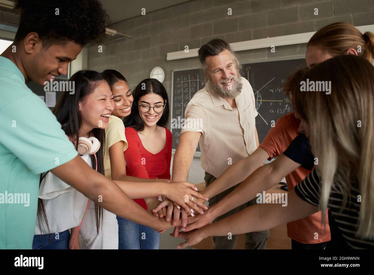 Gruppo di studenti lavoro di squadra con un insegnante. Concetto di mano impilabile. Foto Stock