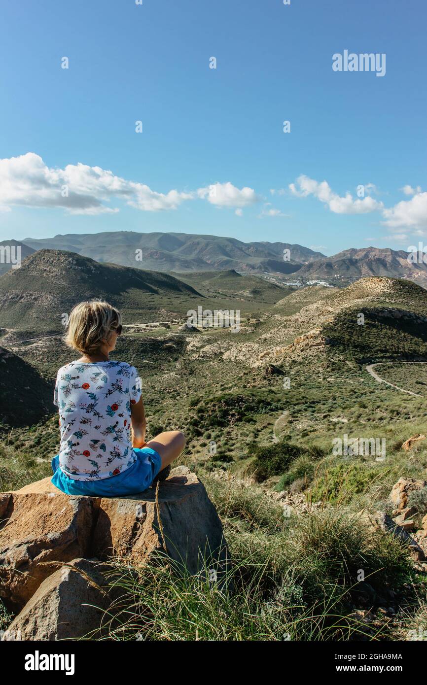 Donna in viaggio da solo godendo di vedute della Riserva Naturale di Cabo de Gata, Andalusia, Spagna. Zona costiera protetta con paesaggio selvaggio isolato e vulcano Foto Stock