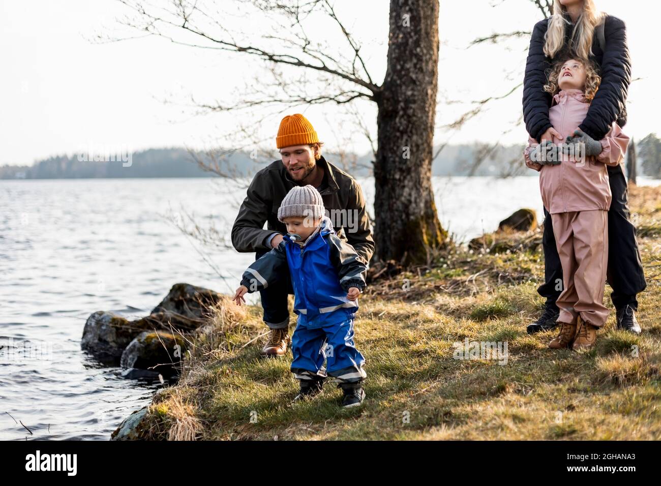 Uomo e donna con figlio e figlia al lago al parco Foto Stock