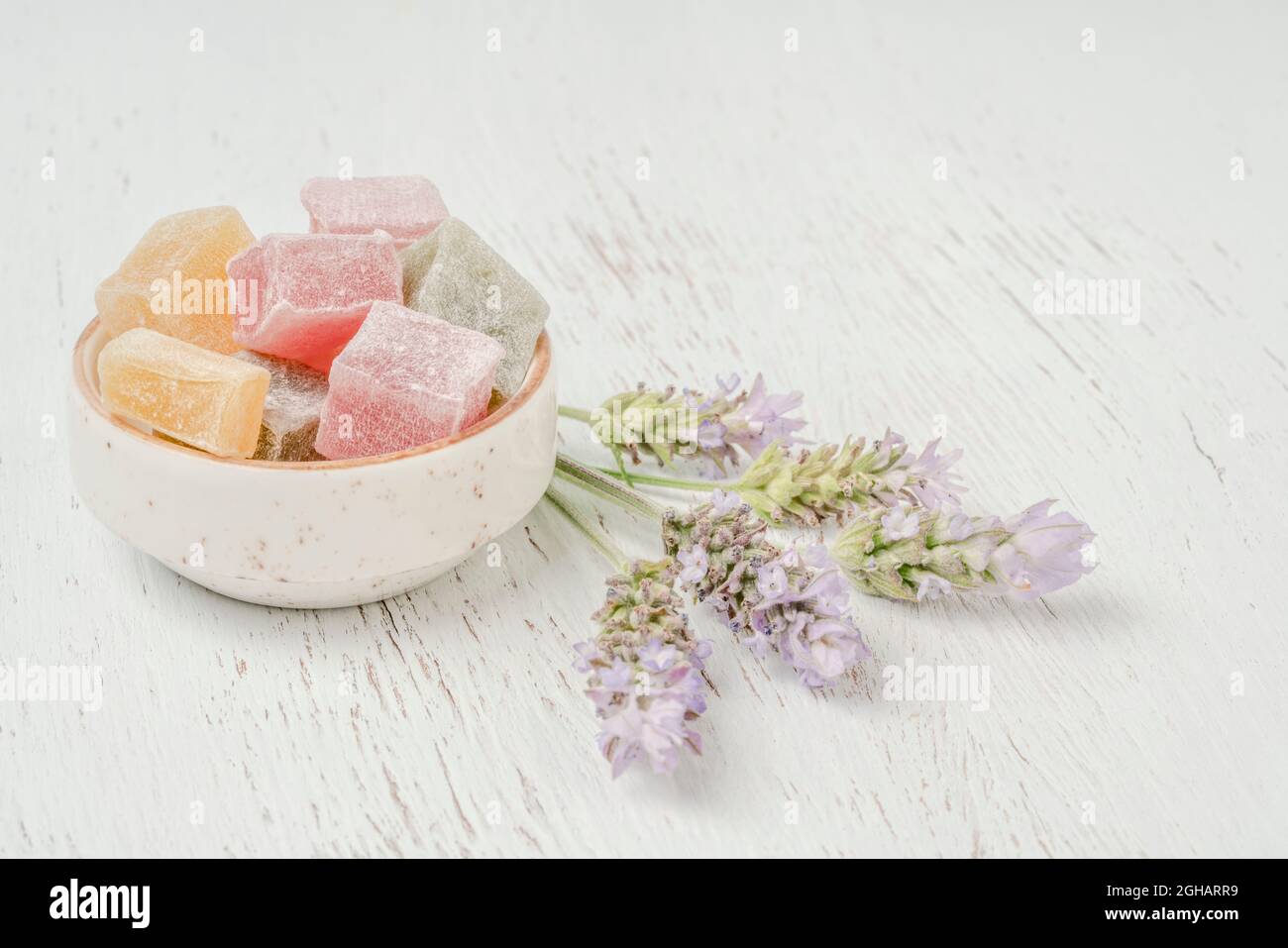 Colorate delizie turche su un tavolo di legno decorato con fiori di lavanda con spazio copia Foto Stock