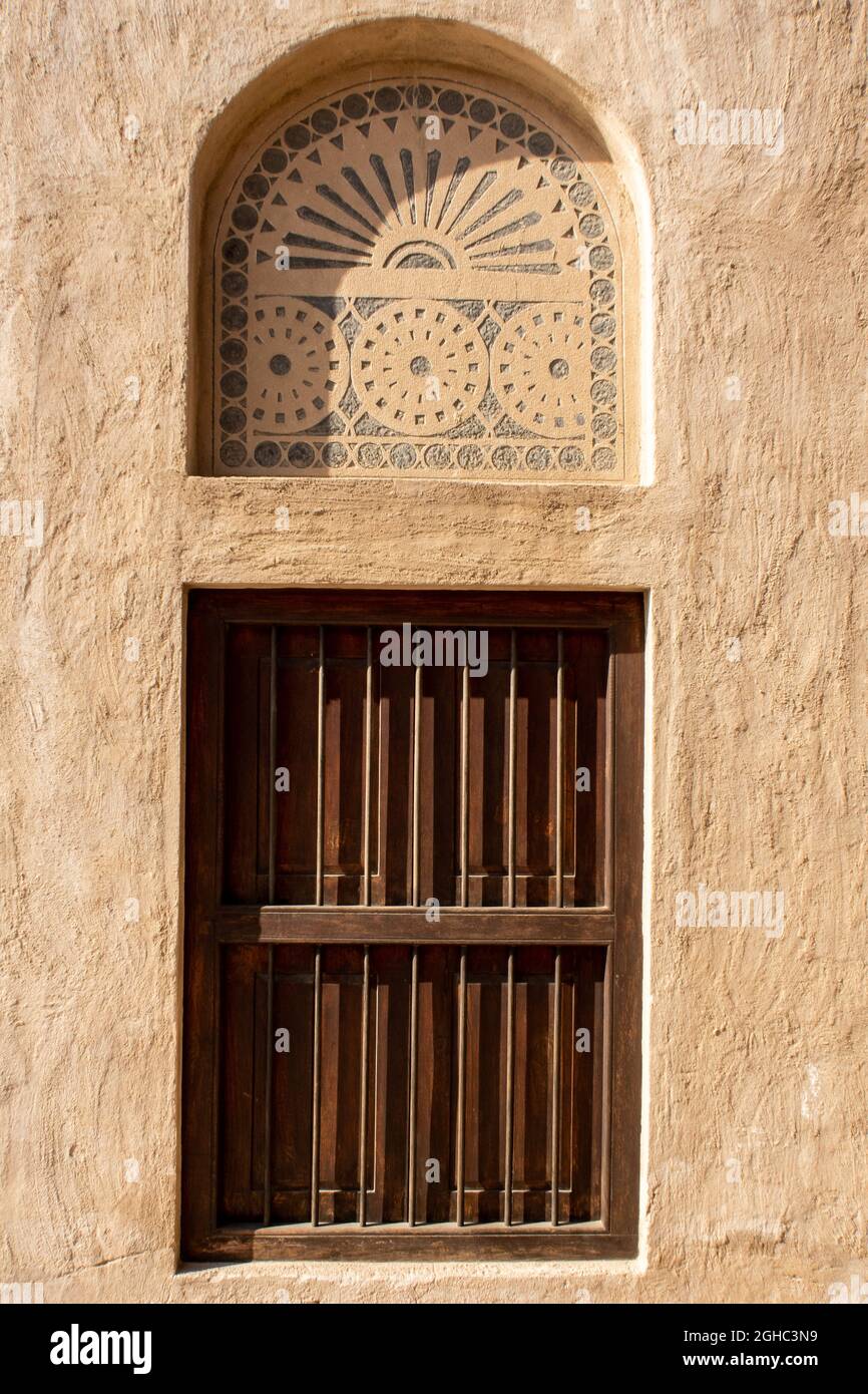 Portale in legno con finestra ad arco in pietra con ornamenti, architettura tradizionale arabica, al Fahidi, Dubai, Emirati Arabi Uniti. Foto Stock