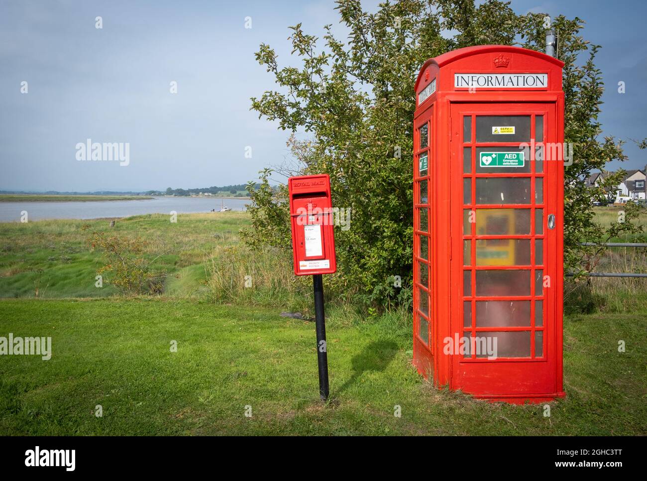 Vecchia cassetta postale Royal Mail e un defibrillatore di emergenza in un vecchio phonebox rosso, villaggio di Glencaple, Dumfries e Galloway, Scozia. Foto Stock