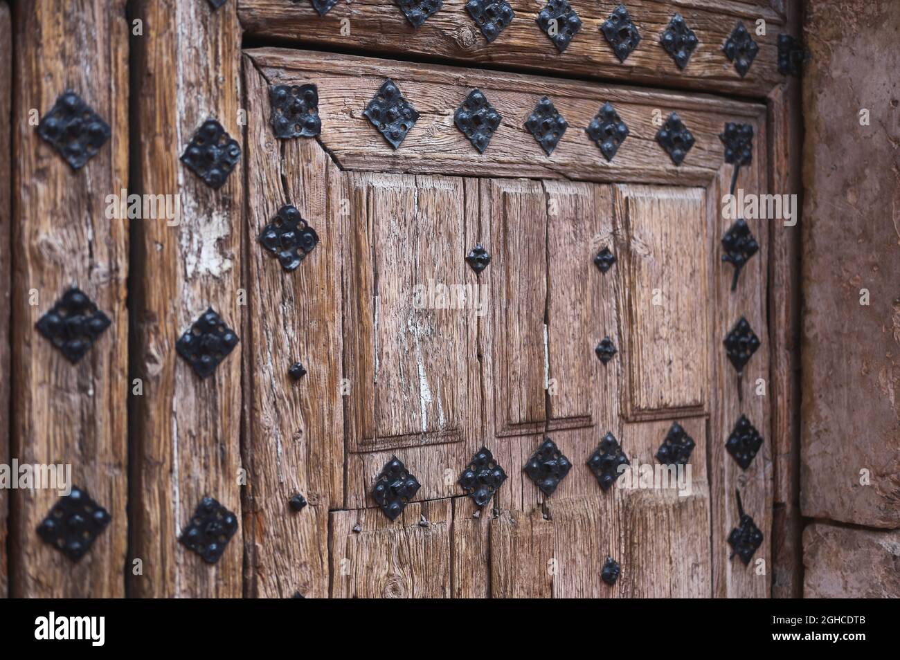 dettaglio di una vecchia porta di legno deteriorata con chiodi Foto Stock