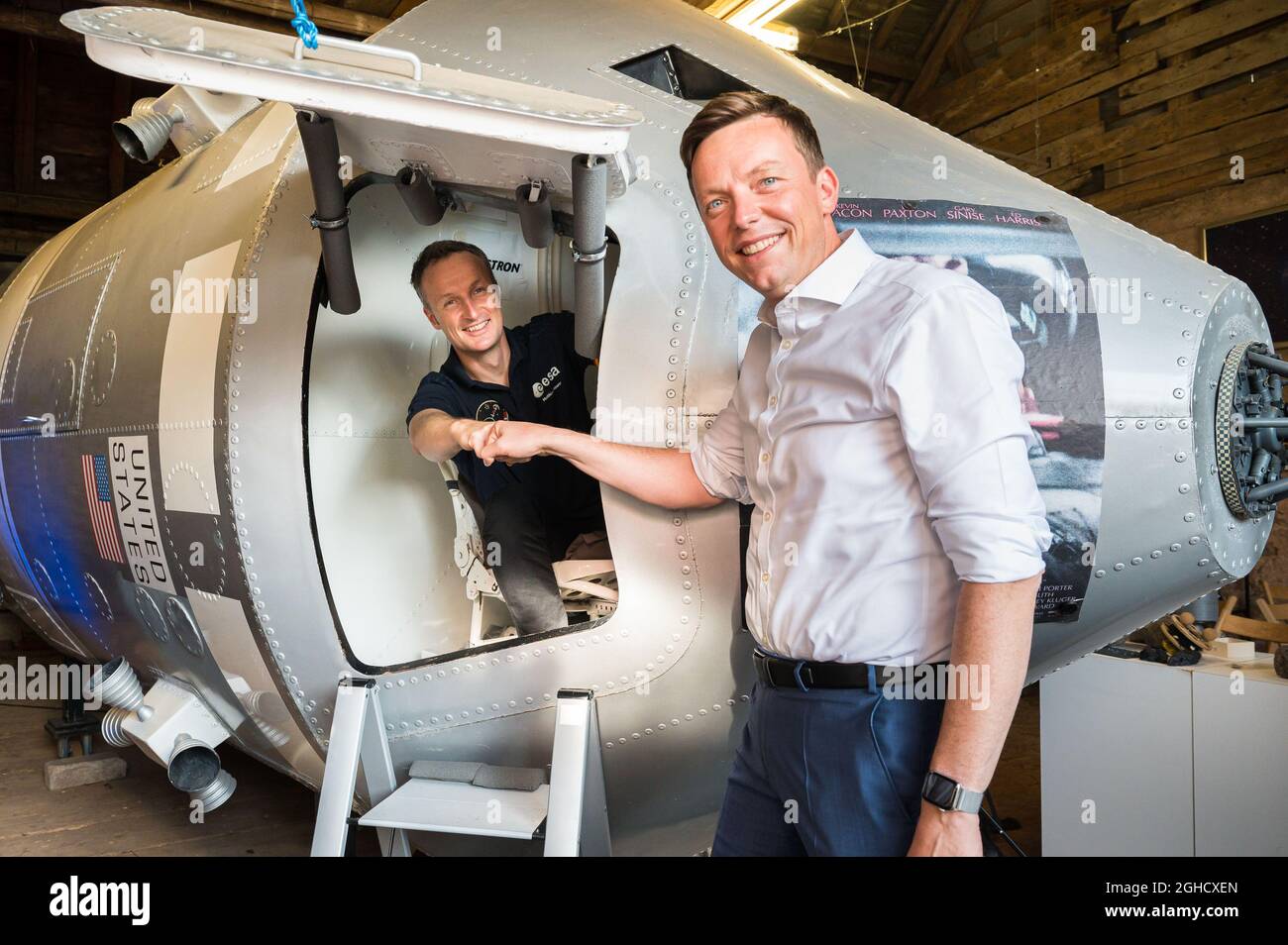 Mosberg Richweiler, Germania. 06 settembre 2021. L'astronauta dell'ESA Matthias Maurer (l) siede in una copia della capsula spaziale Apollo 13 ed è accolto con un pugno dal Presidente del Ministro della Saar Tobias Hans (CDU). Maurer volerà nello spazio alla fine di ottobre. Credit: Oliver Dietze/dpa/Alamy Live News Foto Stock