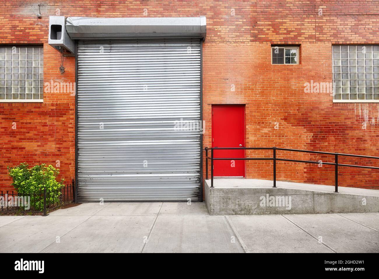 Strada vuota con muratura in mattoni con serranda automatica, New York, USA. Foto Stock