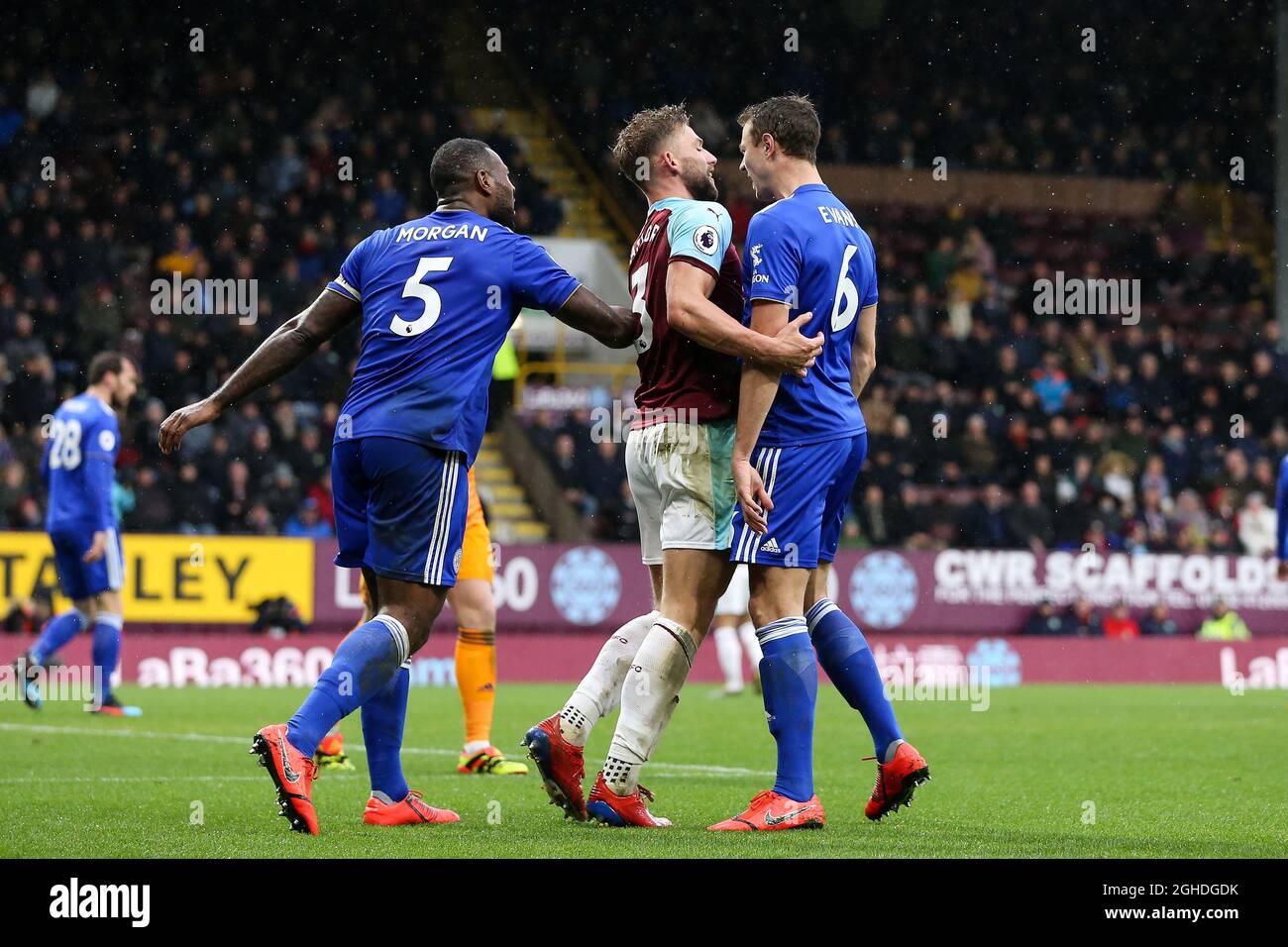 WES Morgan (L) e Jonny Evans (r) di Leicester City si scontrano con Charlie Taylor di Burnley dopo che è calato nella zona di rigore durante la partita della Premier League al Turf Moor Stadium di Burnley. Data foto: 16 marzo 2019. Il credito d'immagine dovrebbe essere: James Wilson/Sportimage via PA Images Foto Stock