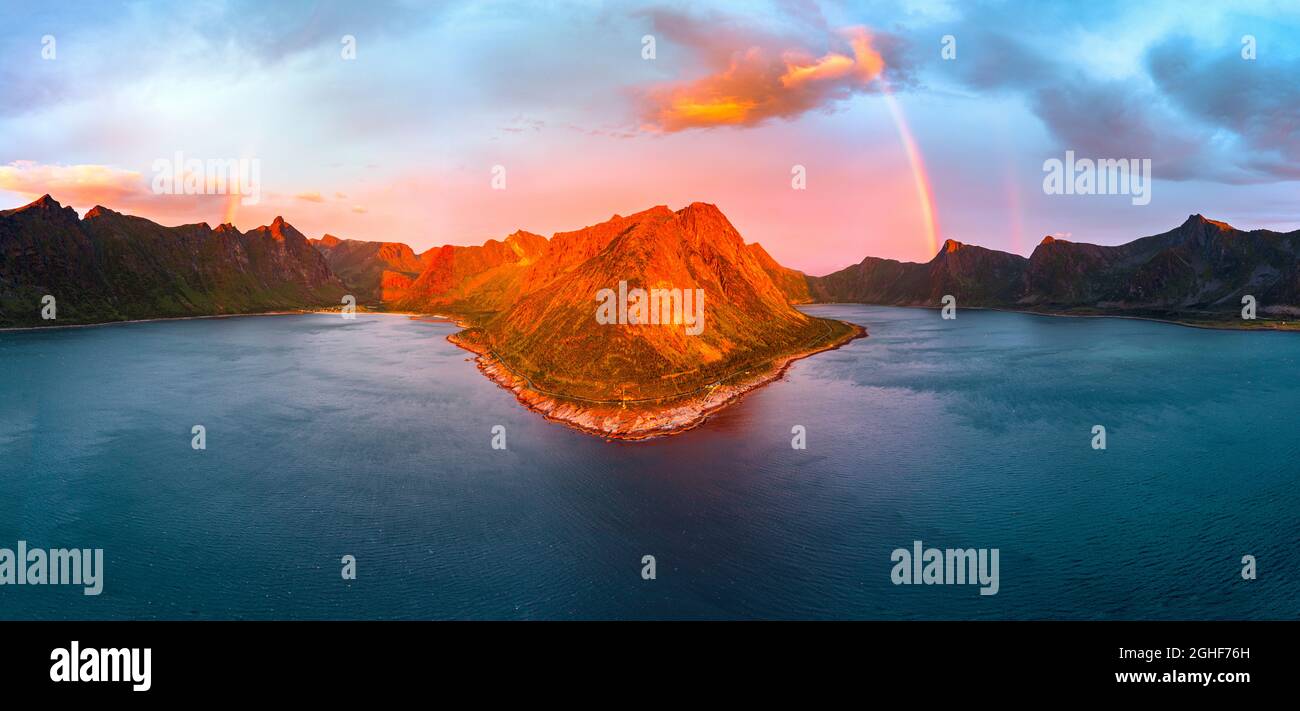 Vista aerea delle montagne di Ersfjord e Steinfjord illuminato da arcobaleno e sole di mezzanotte, Tungeneset, Senja, contea di Troms, Norvegia Foto Stock