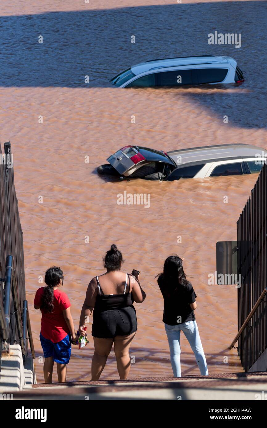 La gente del posto guarda i veicoli abbandonati e le strade del centro allagate nelle strane conseguenze dell'uragano Ida. Foto Stock