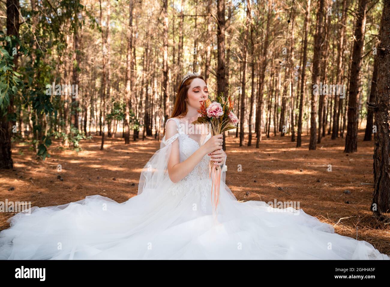 Sposa con abito da sposa bianco in foresta con bouquet da sposa colorato e secco. . Foto di alta qualità Foto Stock