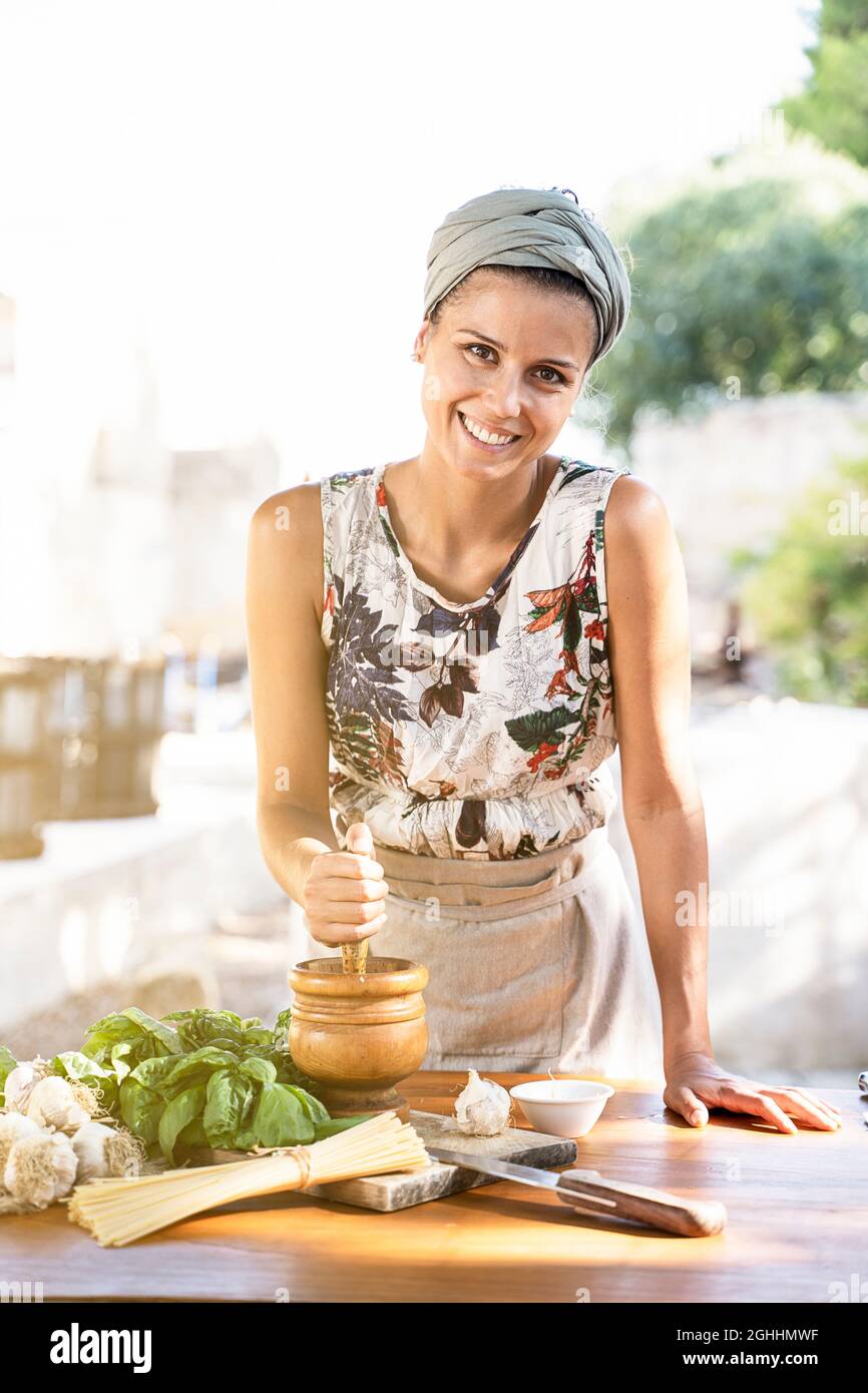 Giovane donna cucina sana cucina mediterranea all'aperto. Stile di vita concetto Foto Stock