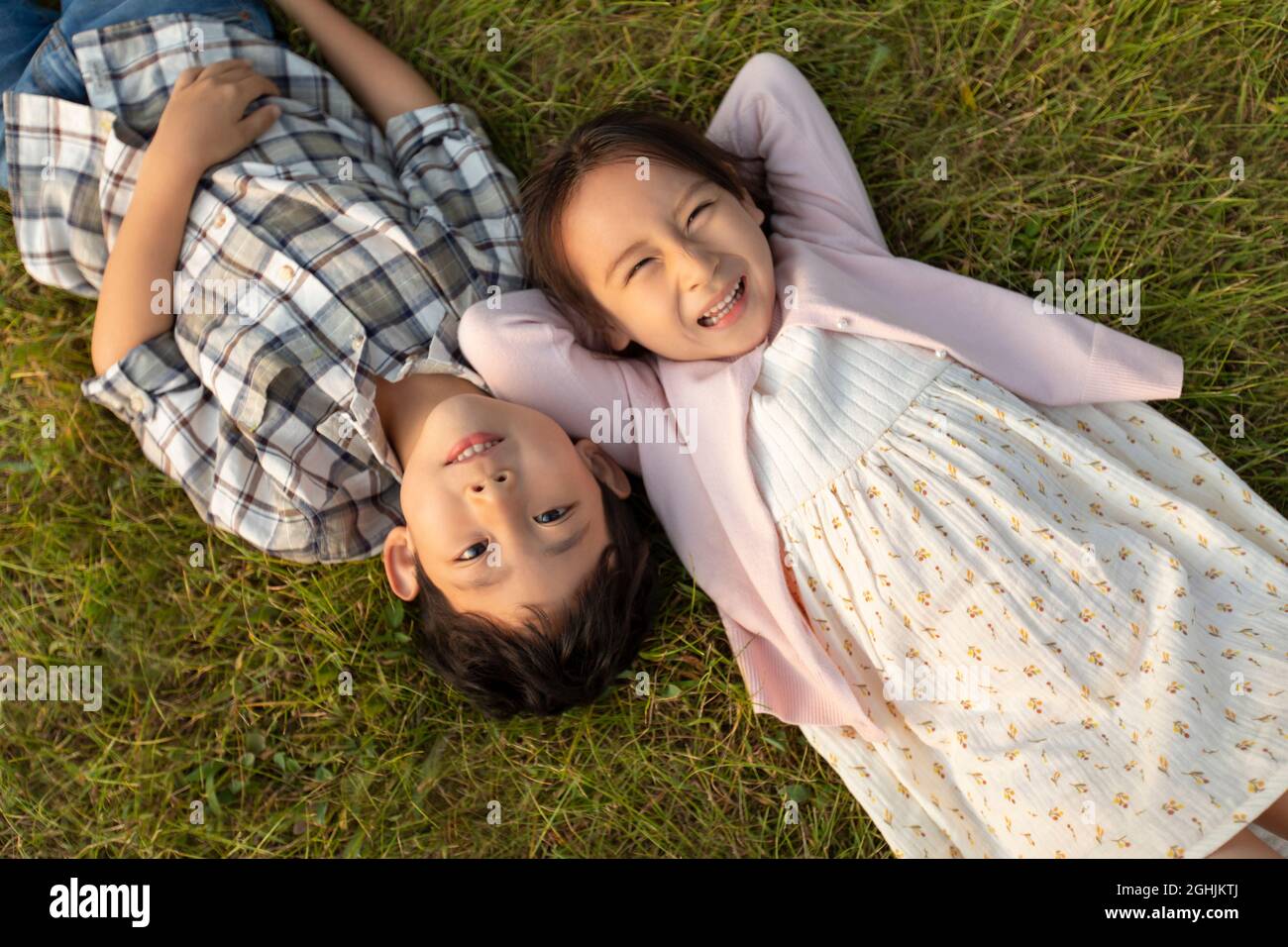 Dei bambini felici sdraiati sull'erba Foto Stock