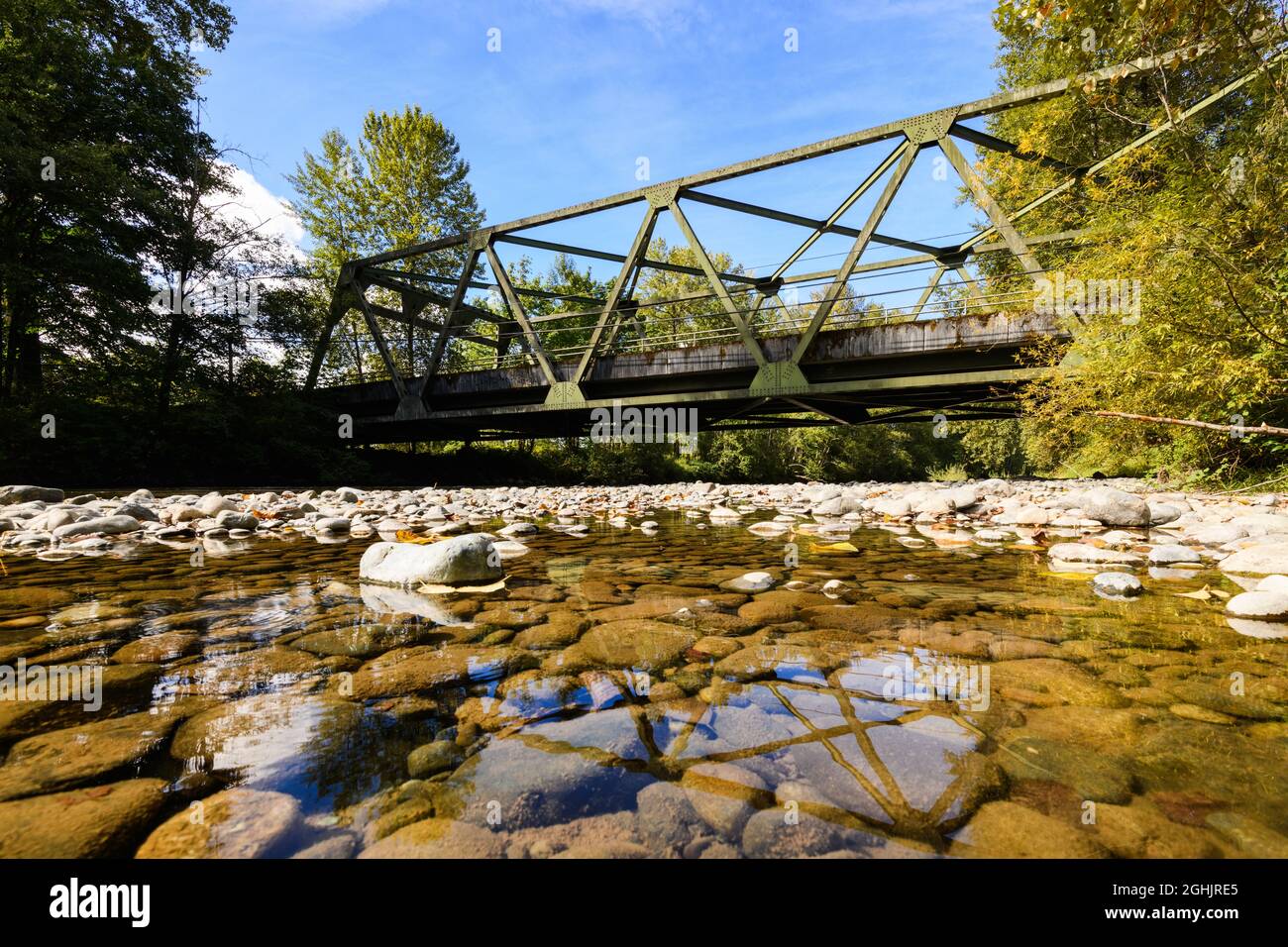 Carnation, WA, USA - 06 settembre 2021; Tolt River passa sotto il ponte della state Route 203 in estate a Carnation Washington. Le rocce del fiume sono esposizioni Foto Stock