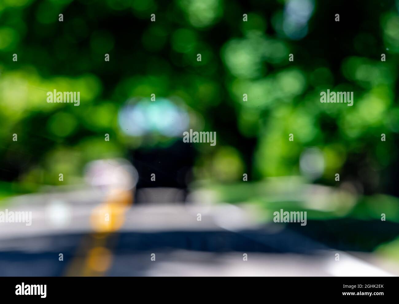 Astratto paesaggio estivo di un veicolo su sfondo verde sfocato Foto Stock