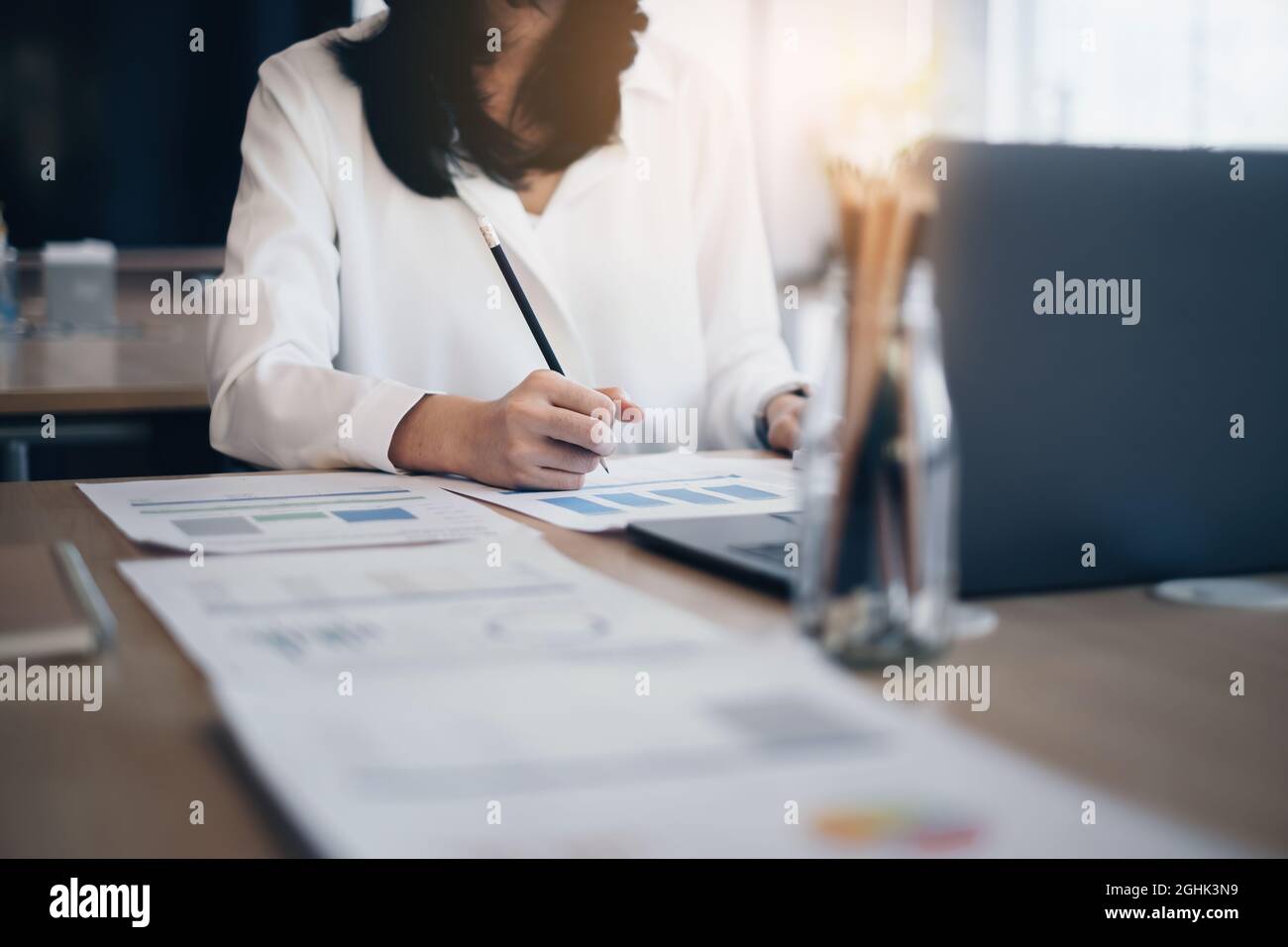 Business donna fare contabilità finanziaria borsa analisi dei grafici di mercato su documenti in ufficio. Foto Stock
