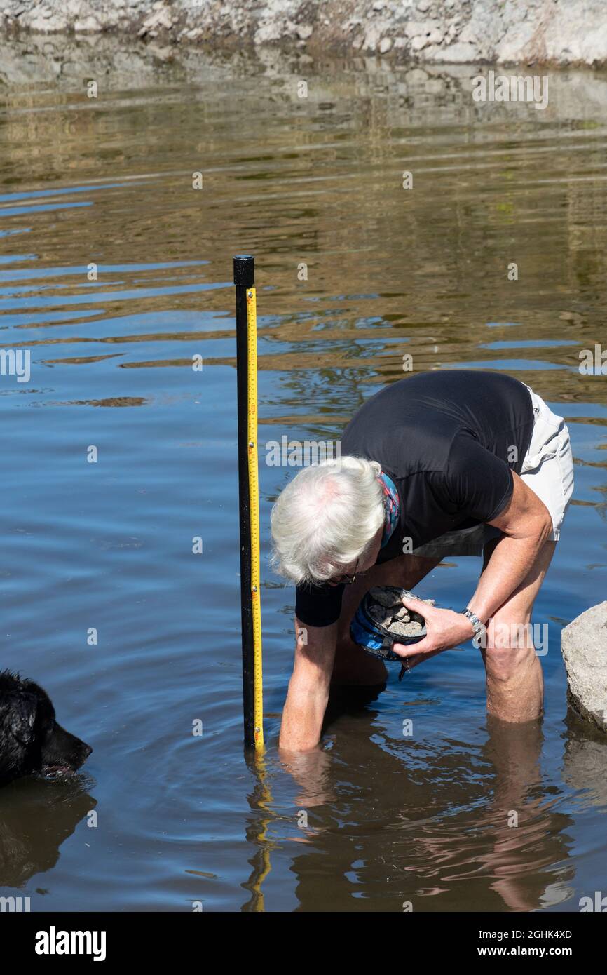 Man che installa l'indicatore di livello dell'acqua in un piccolo serbatoio, Oregon, USA Foto Stock