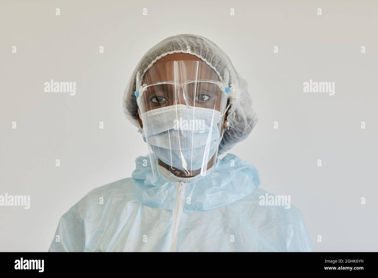 Ritratto di triste grave infermiere medico in PPE vestito guardando la macchina fotografica, è stanca dopo giorno di lavoro Foto Stock