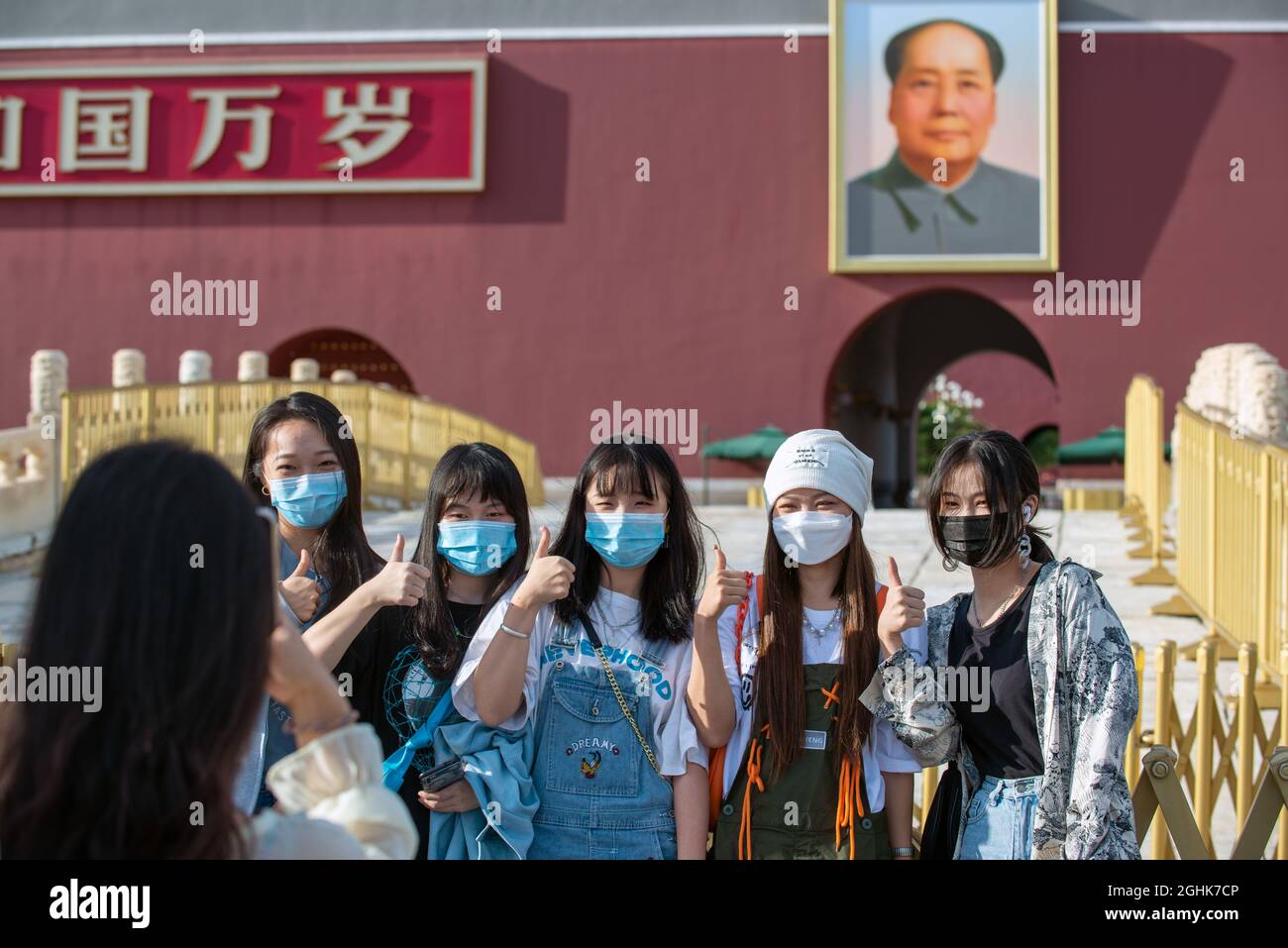 I turisti cinesi che indossano maschere scattano una foto di gruppo davanti alla porta Tiananmen con un ritratto di Mao Zedong. 07 settembre 2021 Foto Stock