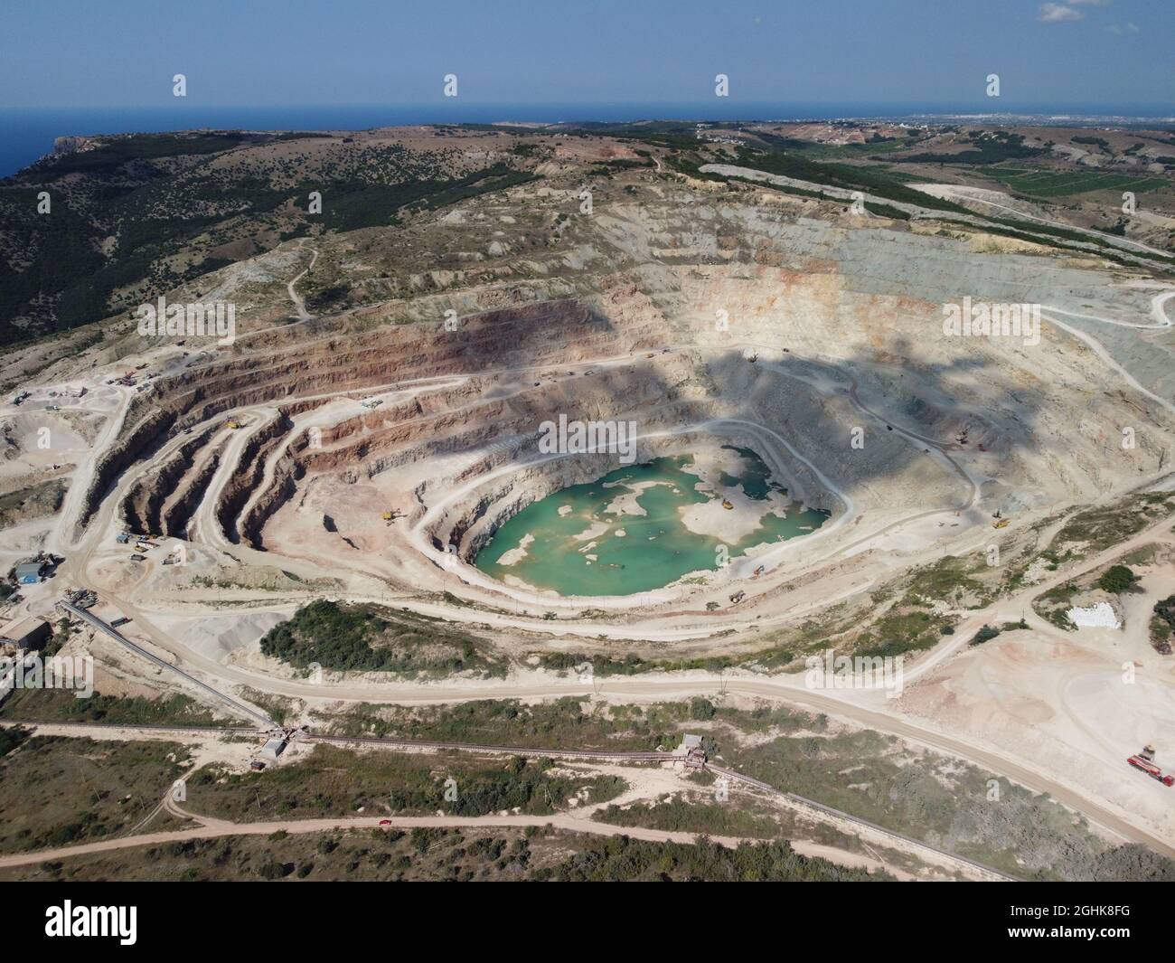 Vista aerea industriale di cave di opencast con molti macchinari in funzione - estrazione di flussi per l'industria metallurgica. Settore minerario ovale Foto Stock