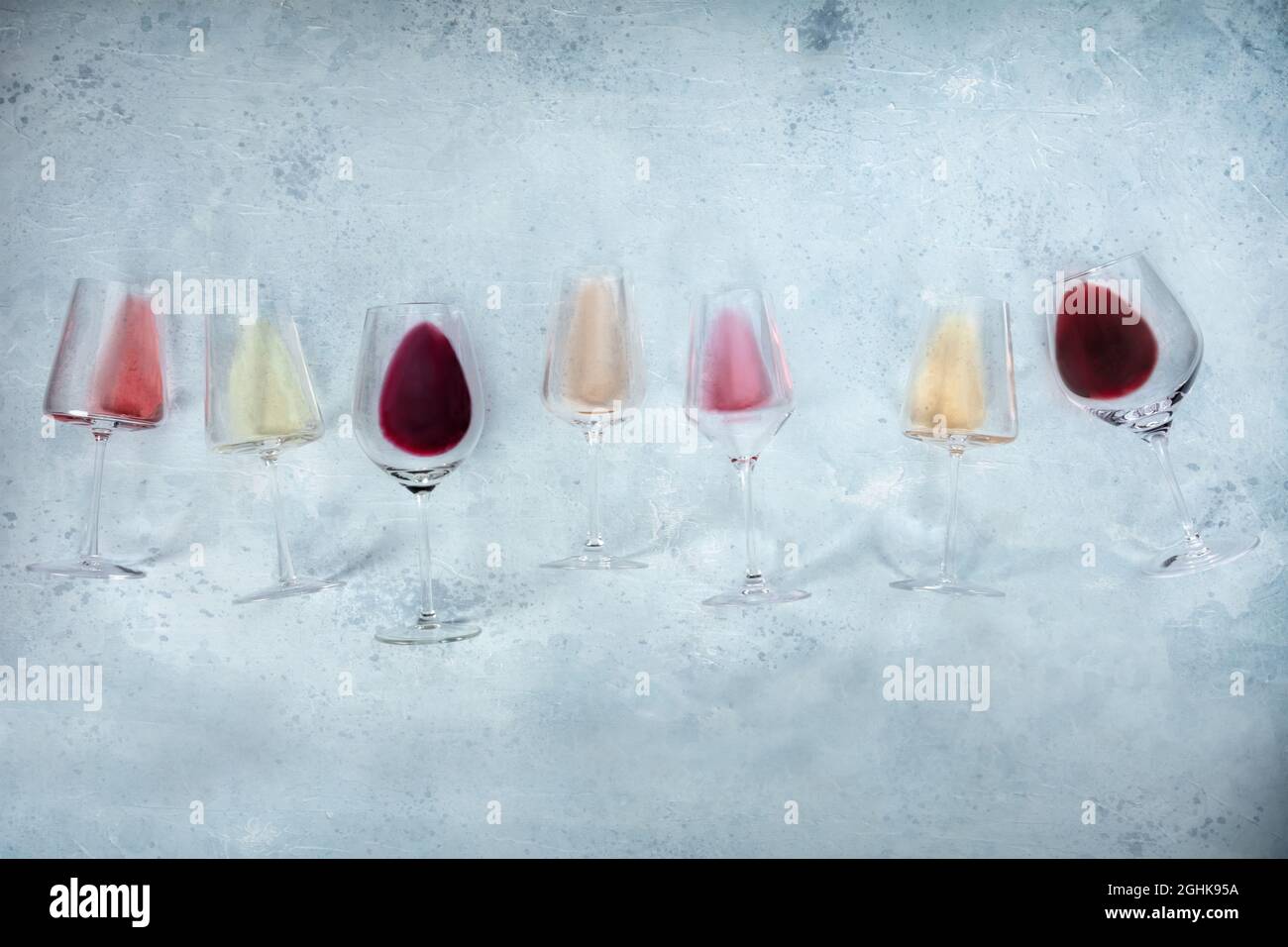Fondo del vino con bicchieri di vino rosa, rosso e bianco, girato dall'alto con spazio copia. Vari colori Foto Stock