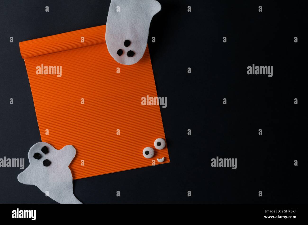 Mackup Halloween. Una foglia arancione vuota su sfondo nero e fantasmi bianchi. Buon Halloween, spazio per il testo Foto Stock