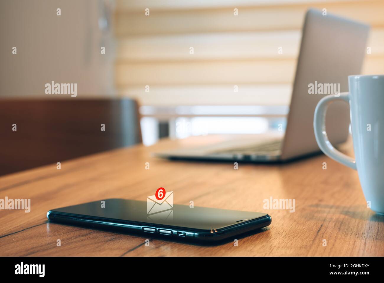 La notifica dei messaggi e-mail viene visualizzata sullo smartphone mobile dell'ufficio domestico, con un focus selettivo Foto Stock