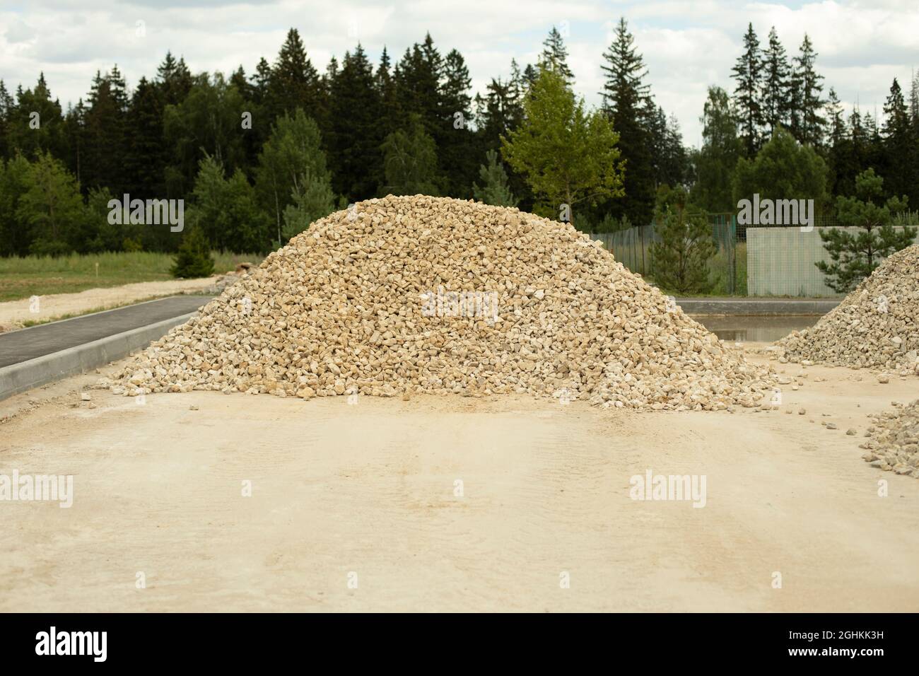 Uno scivolo di macerie su un cantiere. Materiale da costruzione sulla strada. Una piccola pietra si trova sulla strada. Foto Stock
