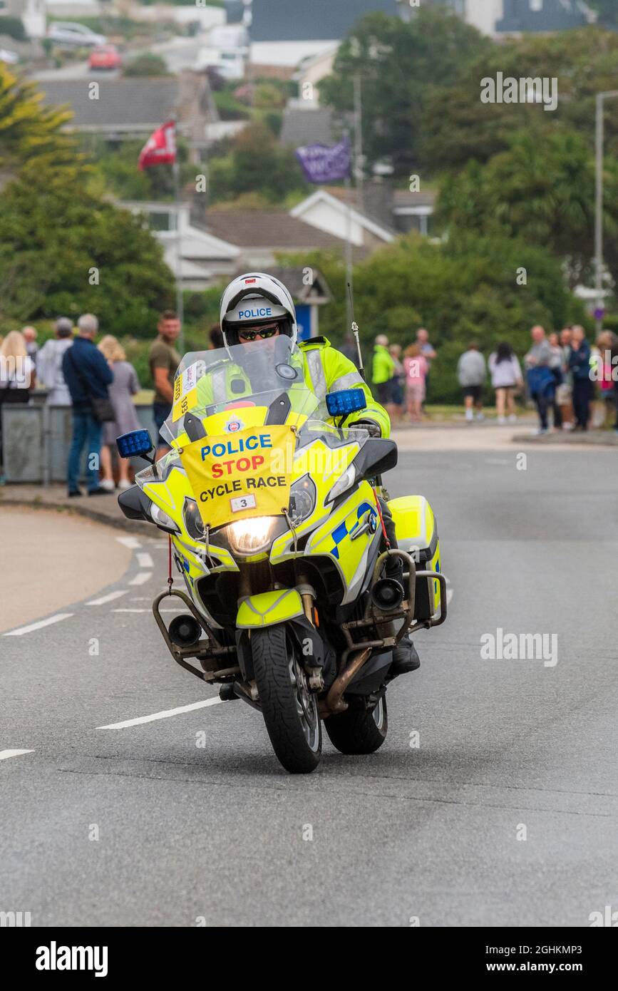 Un motociclista polic pattuglia che guida a Newquay in Cornovaglia durante la fase di apertura del iconico Tour of Britain 2021 - noto come Grand parti. Foto Stock