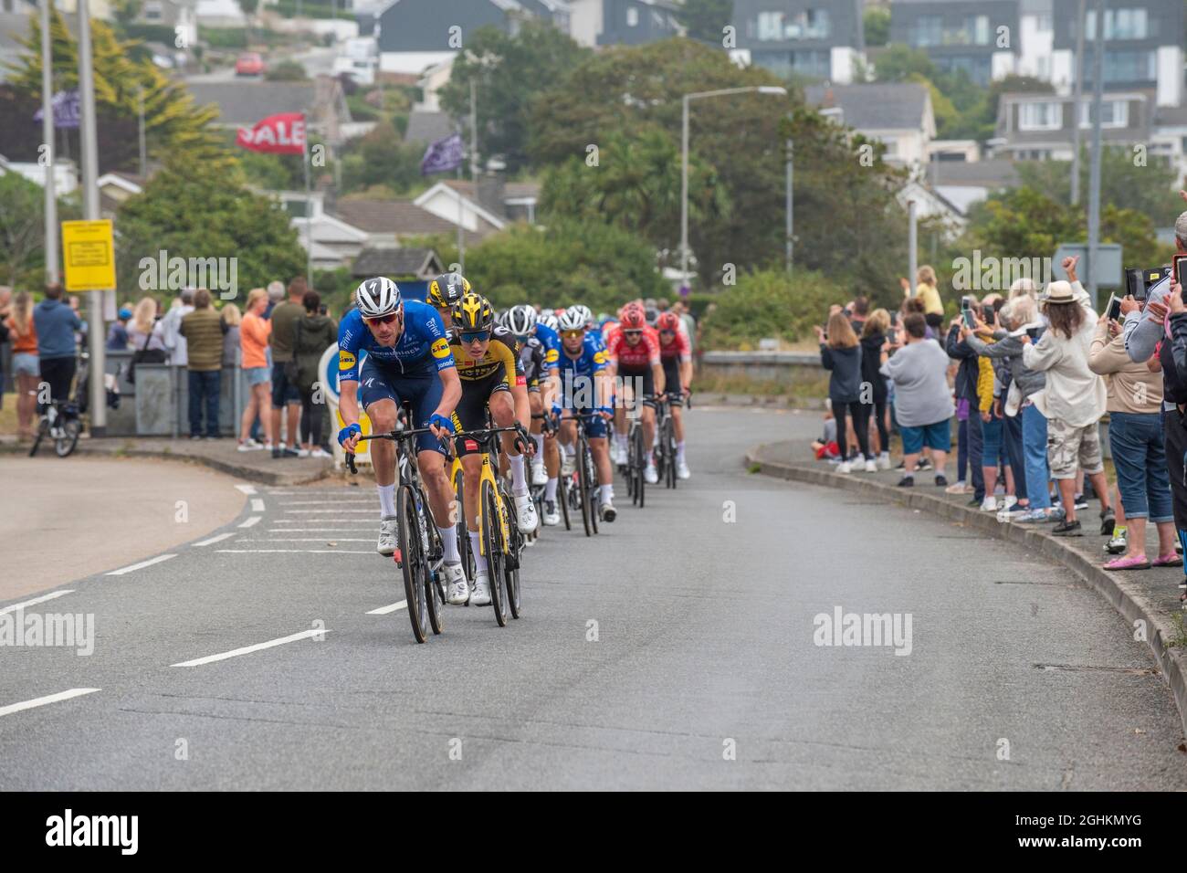 I motociclisti nel pelotone nella fase di apertura dell'iconico Tour of Britain 2021, noto come il Grand partono, in quanto visita la città di Newquay in Cornovaglia Foto Stock