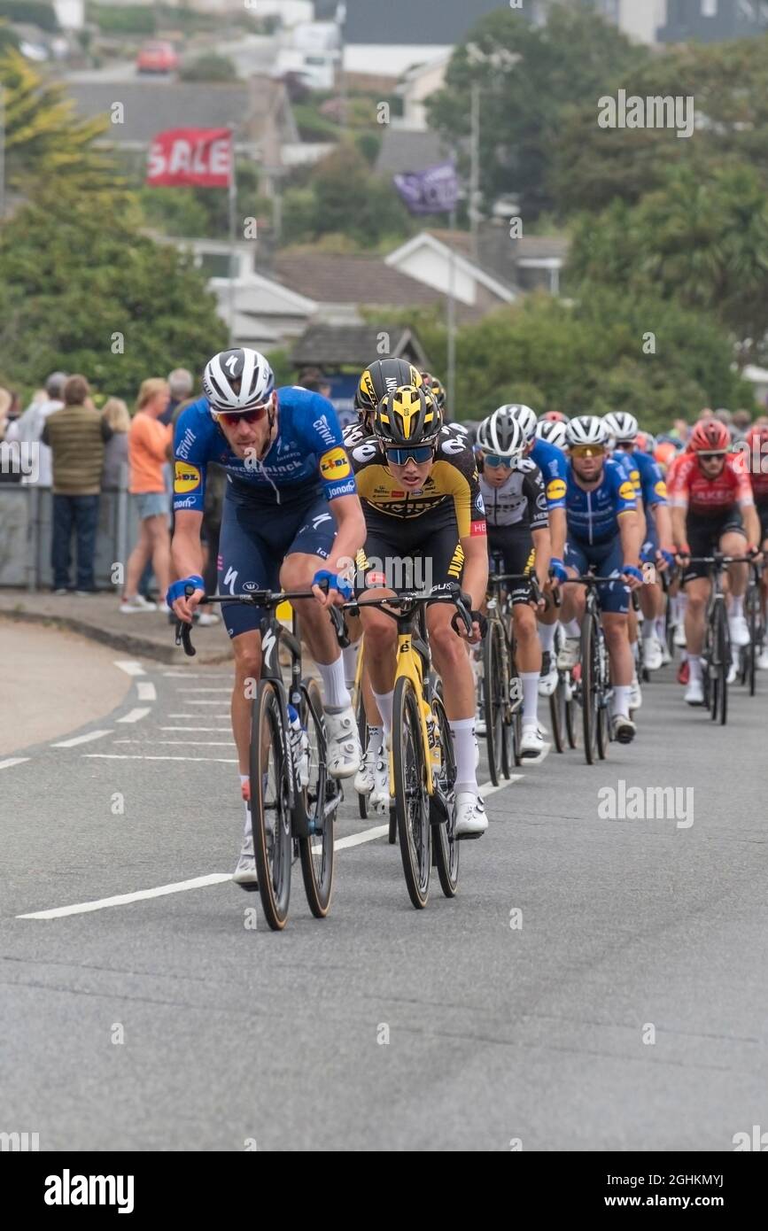 I motociclisti nel pelotone nella fase di apertura dell'iconico Tour of Britain 2021, noto come il Grand partono, in quanto visita la città di Newquay in Cornovaglia Foto Stock