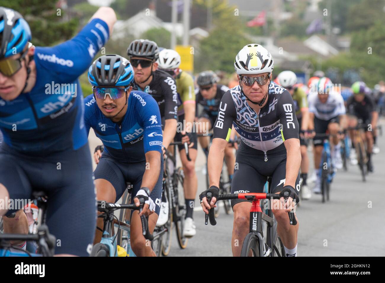 I motociclisti nel pelotone nella fase di apertura dell'iconico Tour of Britain 2021, noto come il Grand partono, in quanto visita la città di Newquay in Cornovaglia Foto Stock