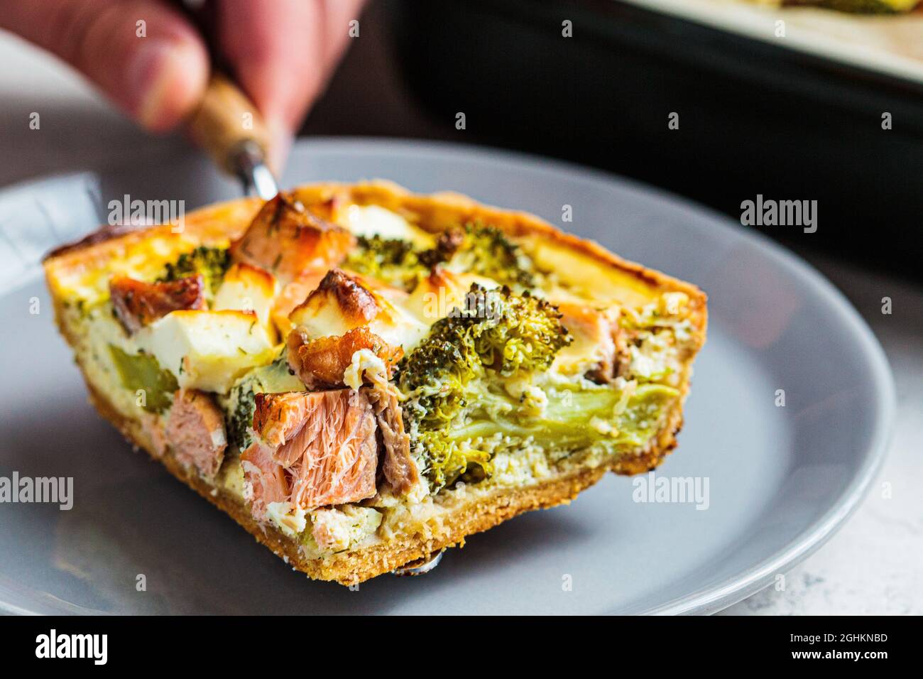 Pezzo di quiche torta con salmone e broccoli in piatto, primo piano. Foto Stock